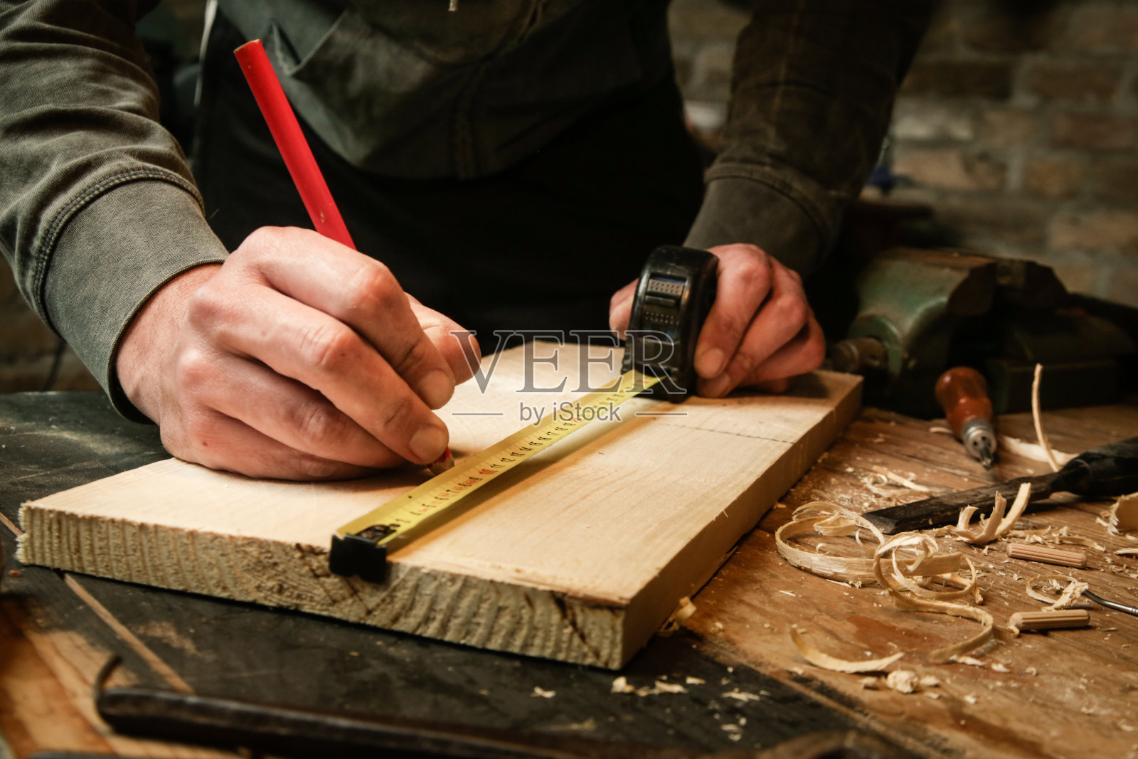 木匠在车间测量和标记木材照片摄影图片