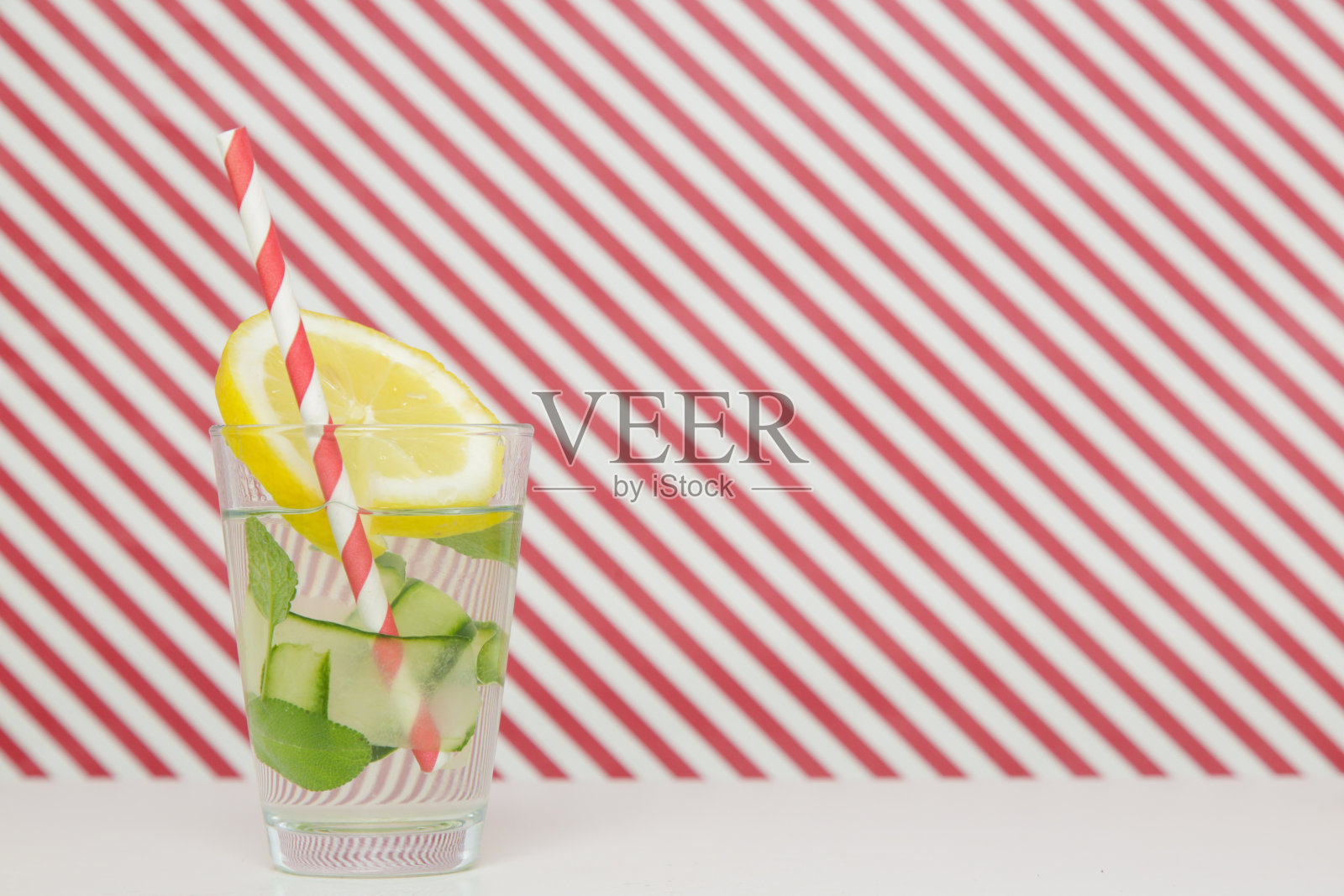 柠檬黄瓜水和彩色纸吸管。健康排毒饮料。照片摄影图片