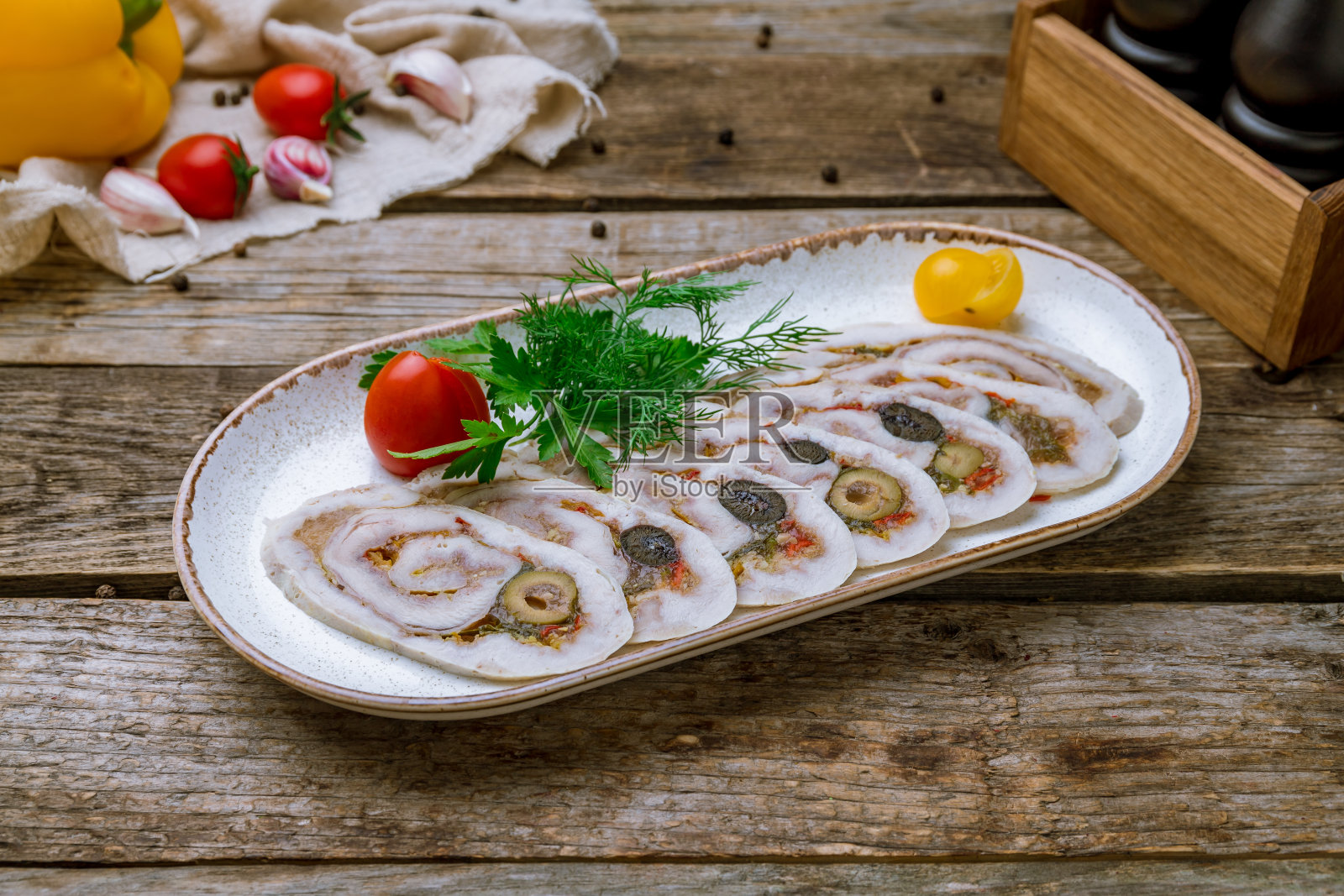 旧木桌上的盘子里放着切好的鸡肉卷照片摄影图片