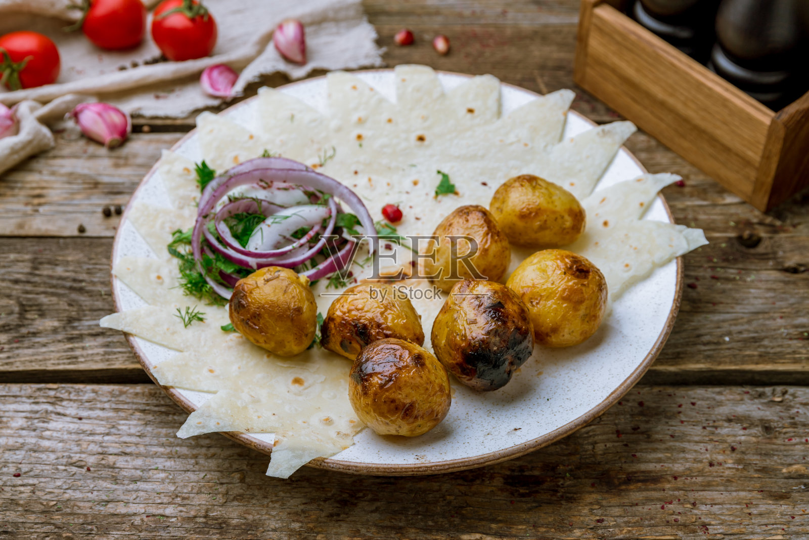 旧木桌上用煤块煎着的烤小土豆照片摄影图片