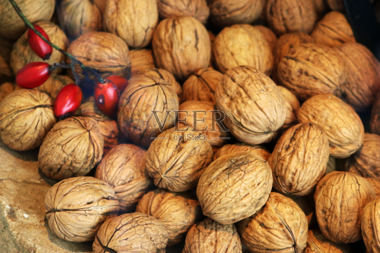 许多核桃壳和一些红色浆果-圣诞食物背景照片摄影图片