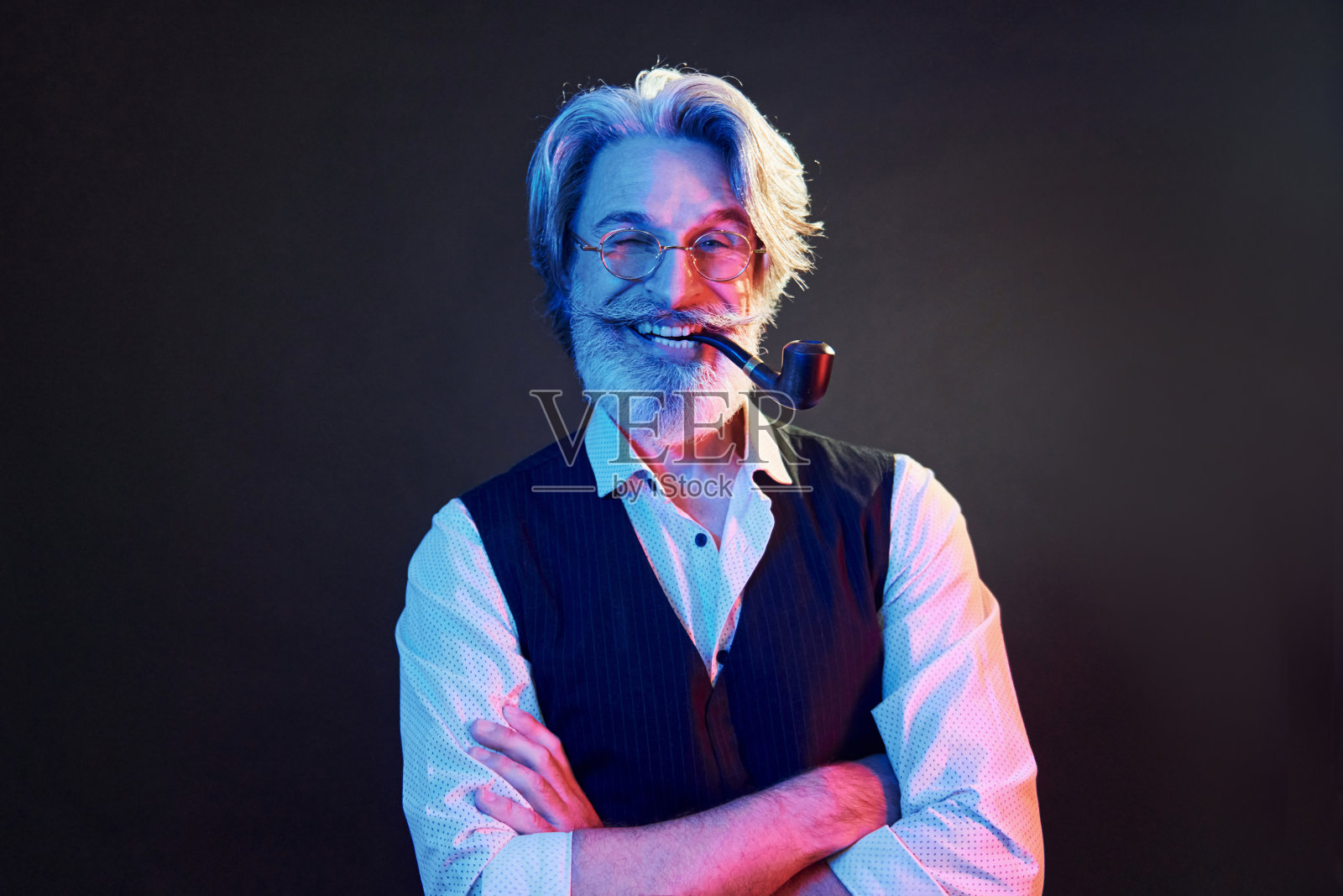 吸烟和玩乐。霓虹灯照明。头发花白、胡须花白、时髦的现代老人在室内照片摄影图片