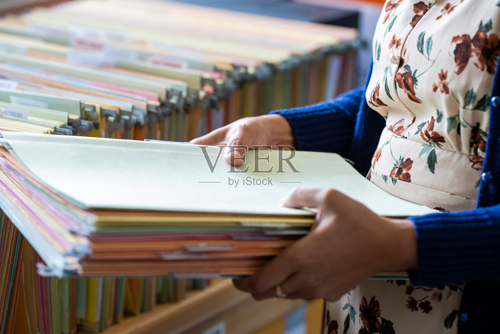 商务妇女在办公室的工作文件堆中搜索信息，照片摄影图片