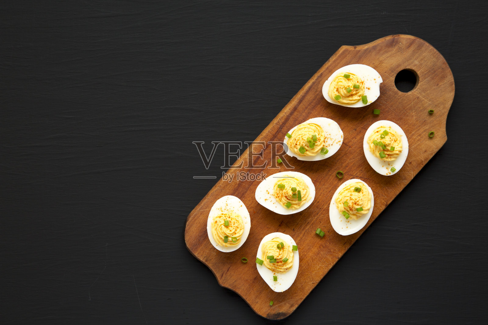 自制韭菜魔鬼蛋放在黑色背景的乡村木板上，俯视图。平躺，头顶上，从上面。副本的空间。照片摄影图片