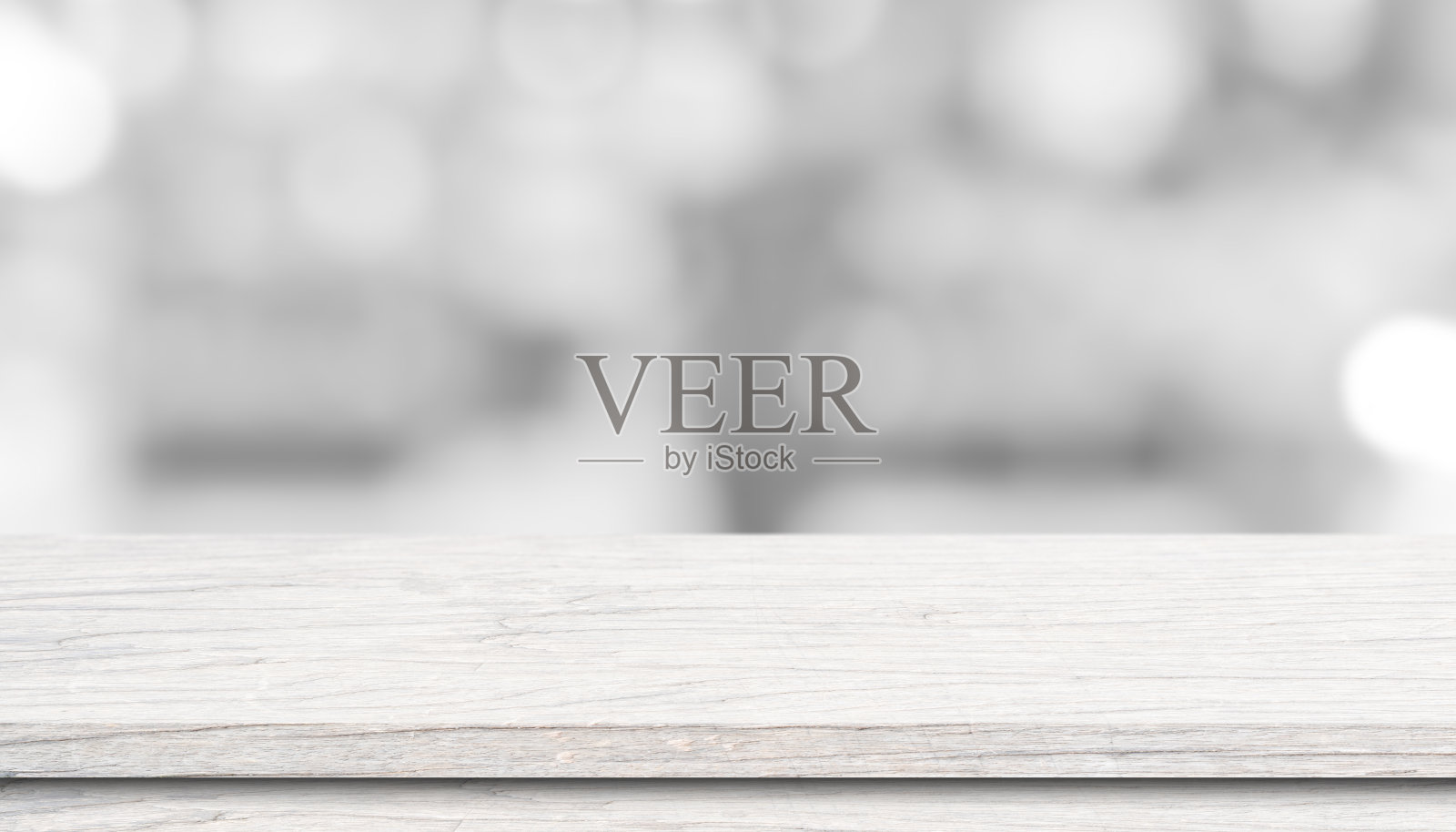 白色木质桌面上方模糊的散景光背景。照片摄影图片