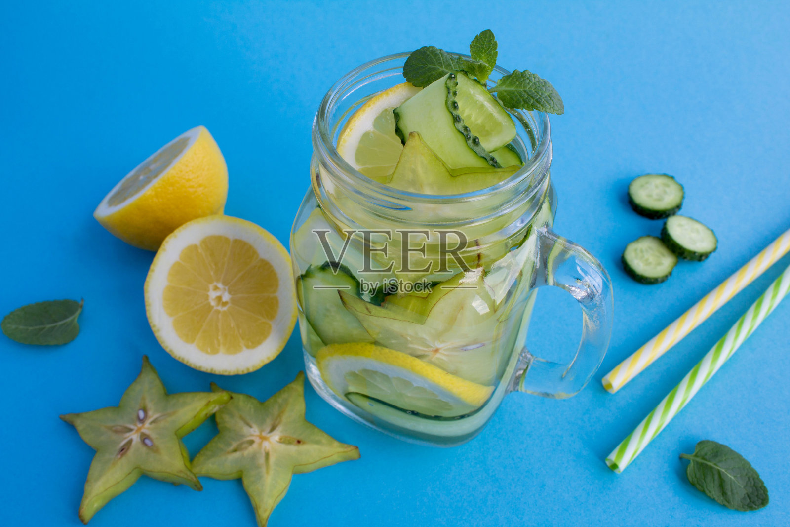 排毒或浸泡水黄瓜，杨桃和柠檬在蓝色的背景照片摄影图片