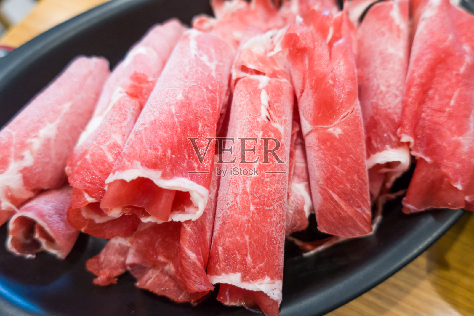 涮涮锅的生牛肉片。照片摄影图片