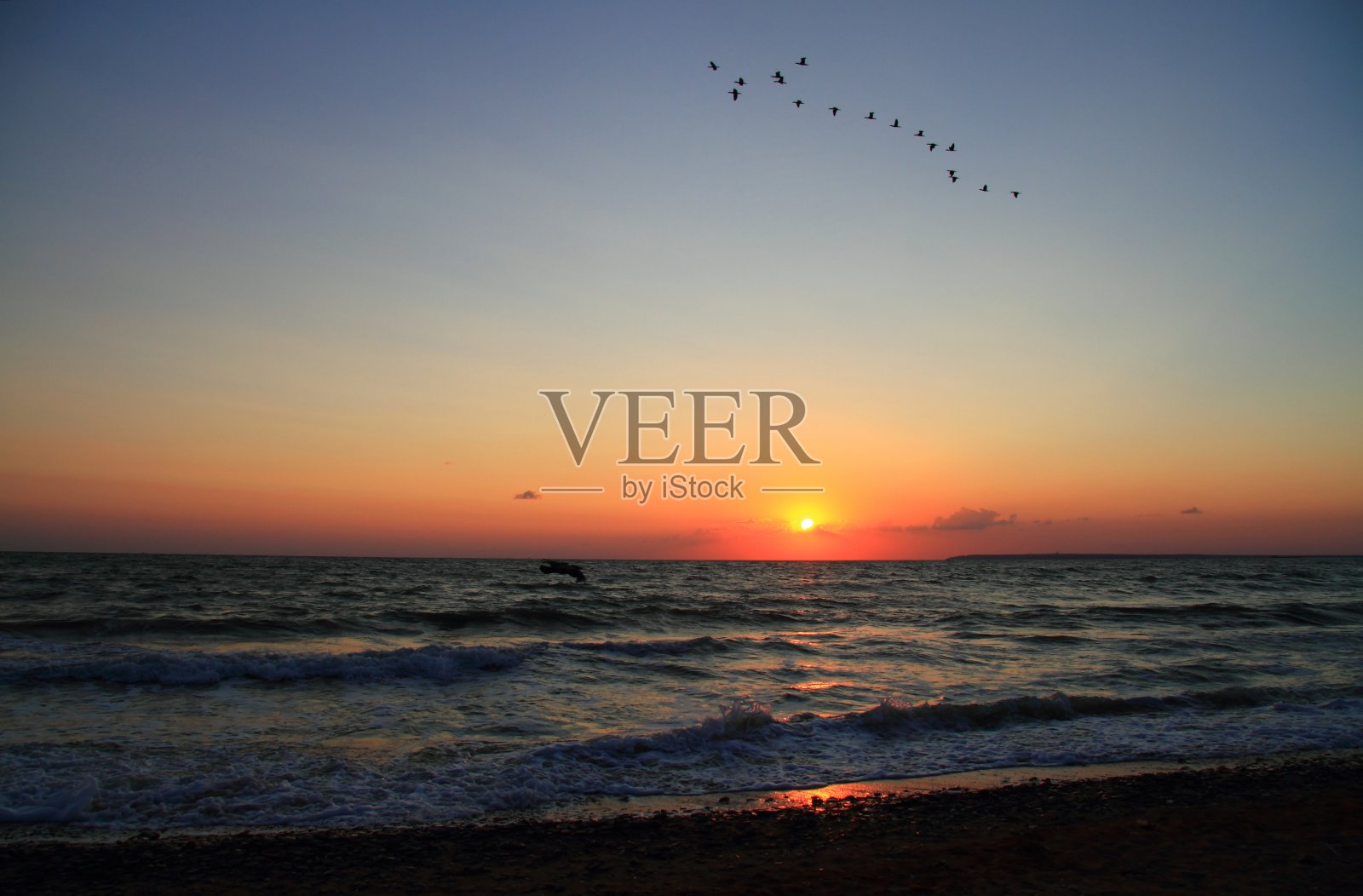 明亮的橙色日出在开阔的海上照片摄影图片