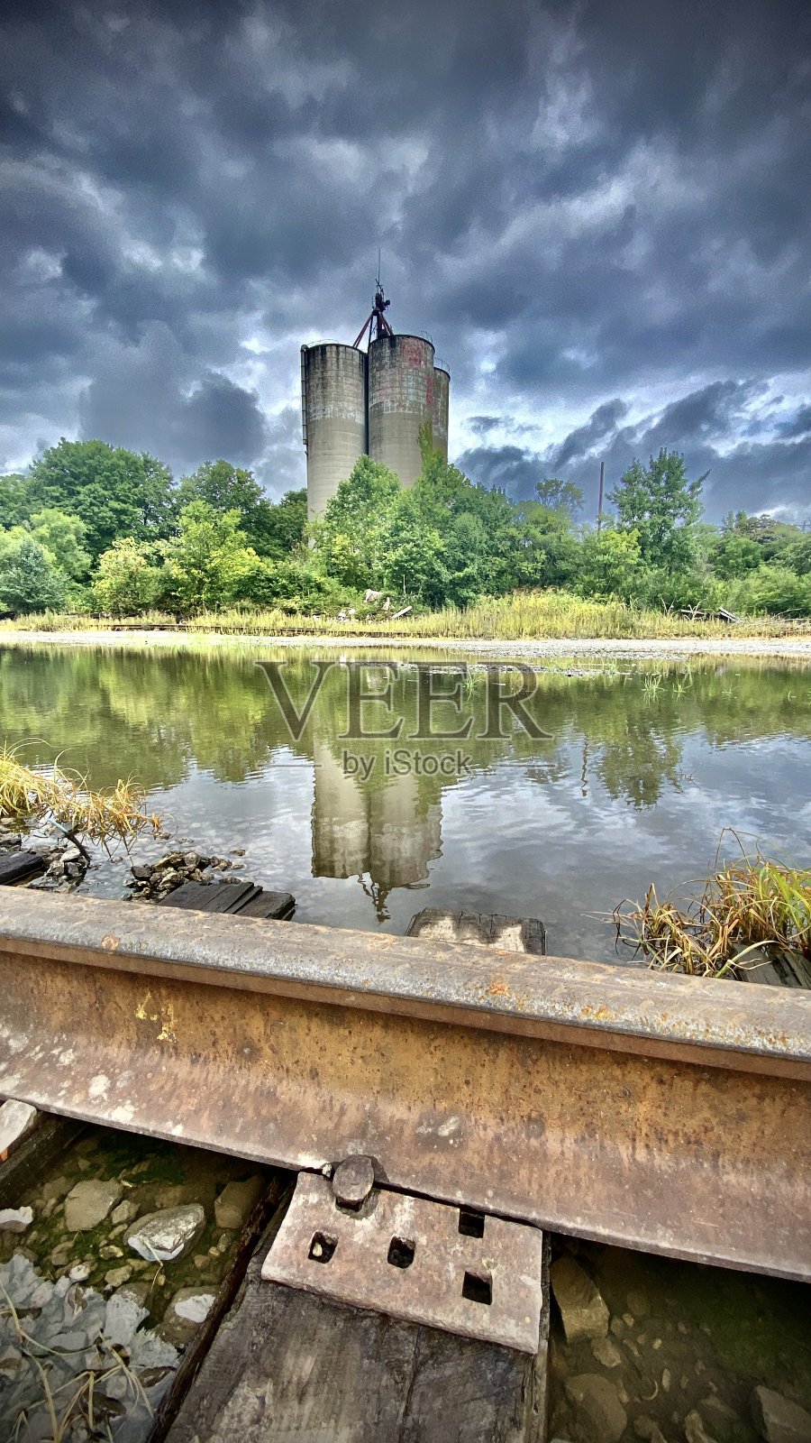 在火车轨道的另一边——可怕的天空和反射的玉米筒仓照片摄影图片