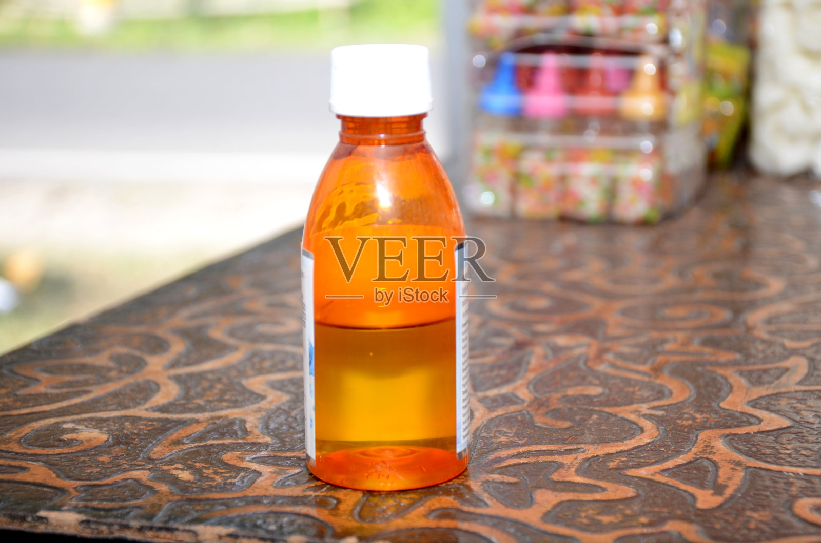 黄色消毒液的塑料瓶在棕黄色的底色上。照片摄影图片