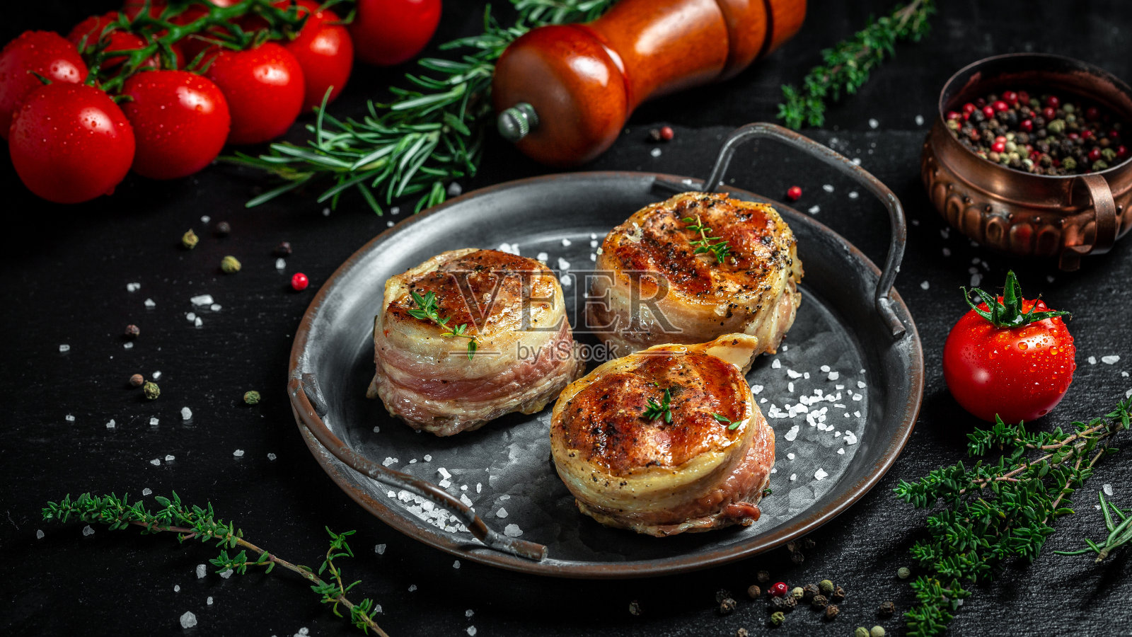 有机培根牛肉卷配香草。大奖章牛排从牛肉里脊覆盖培根在老肉托盘照片摄影图片