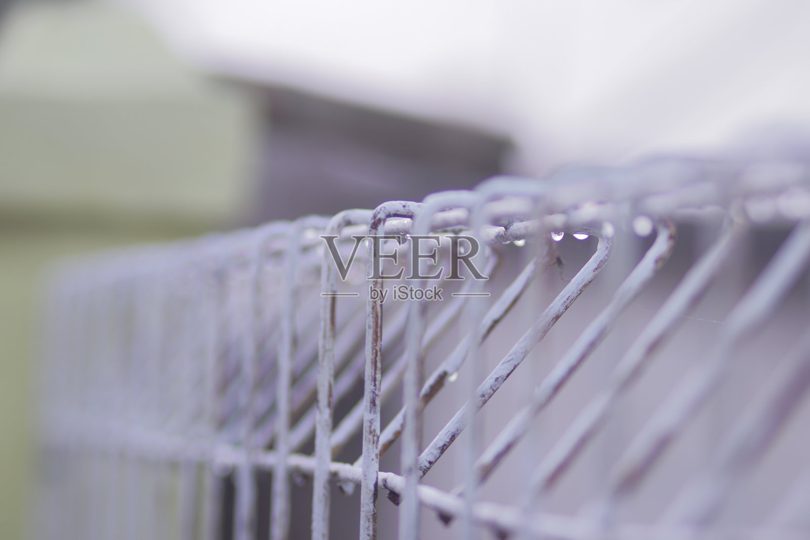 白色金属栅栏上的雨滴。雨滴库存图片。照片摄影图片