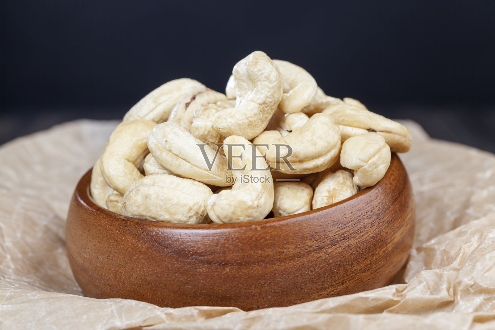 在一张旧木桌和一个木碗里放着腰果照片摄影图片