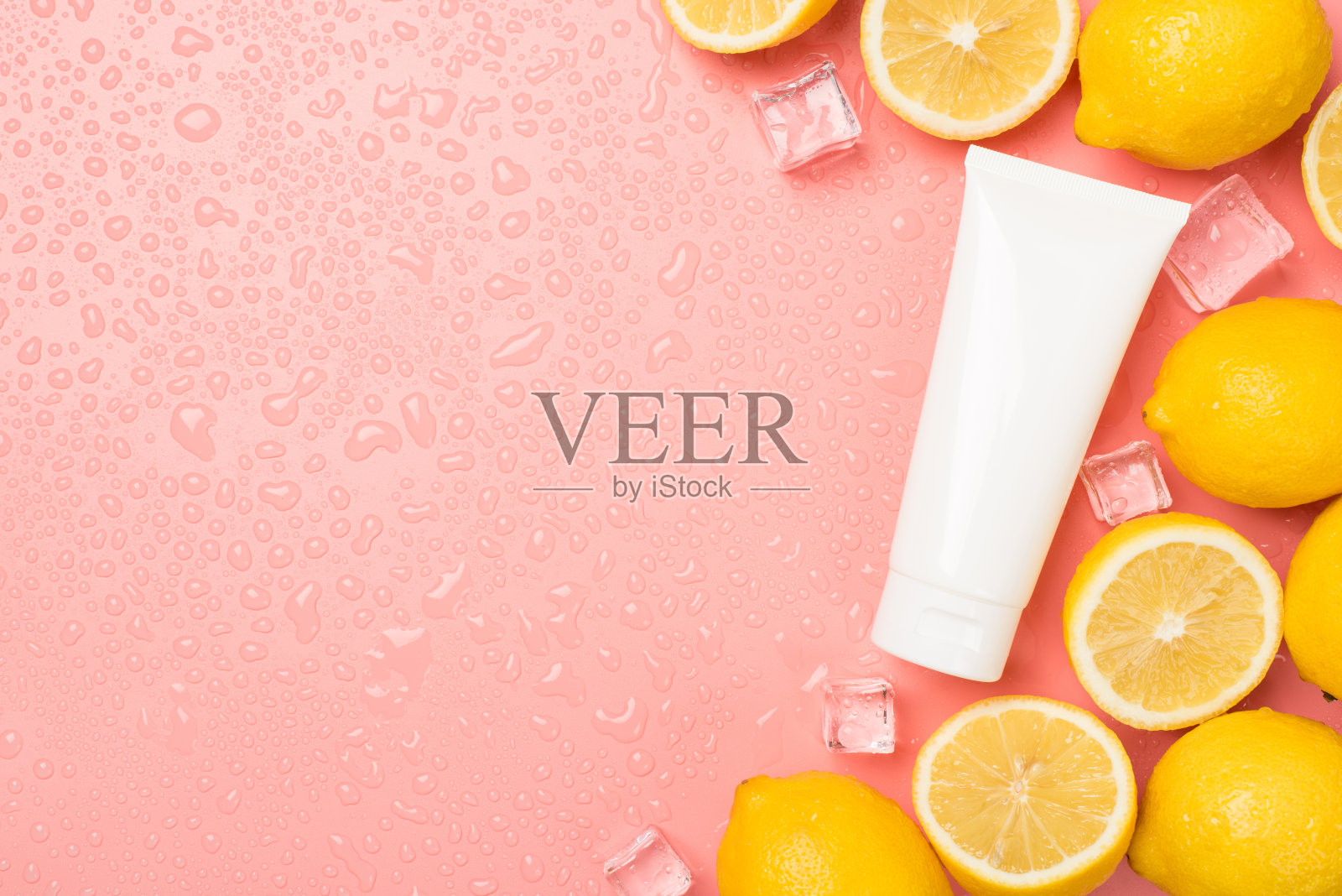 顶部视图照片的白色奶油管切割和整个柠檬冰块在右边的水滴在孤立的淡粉色背景与copyspace在左边照片摄影图片