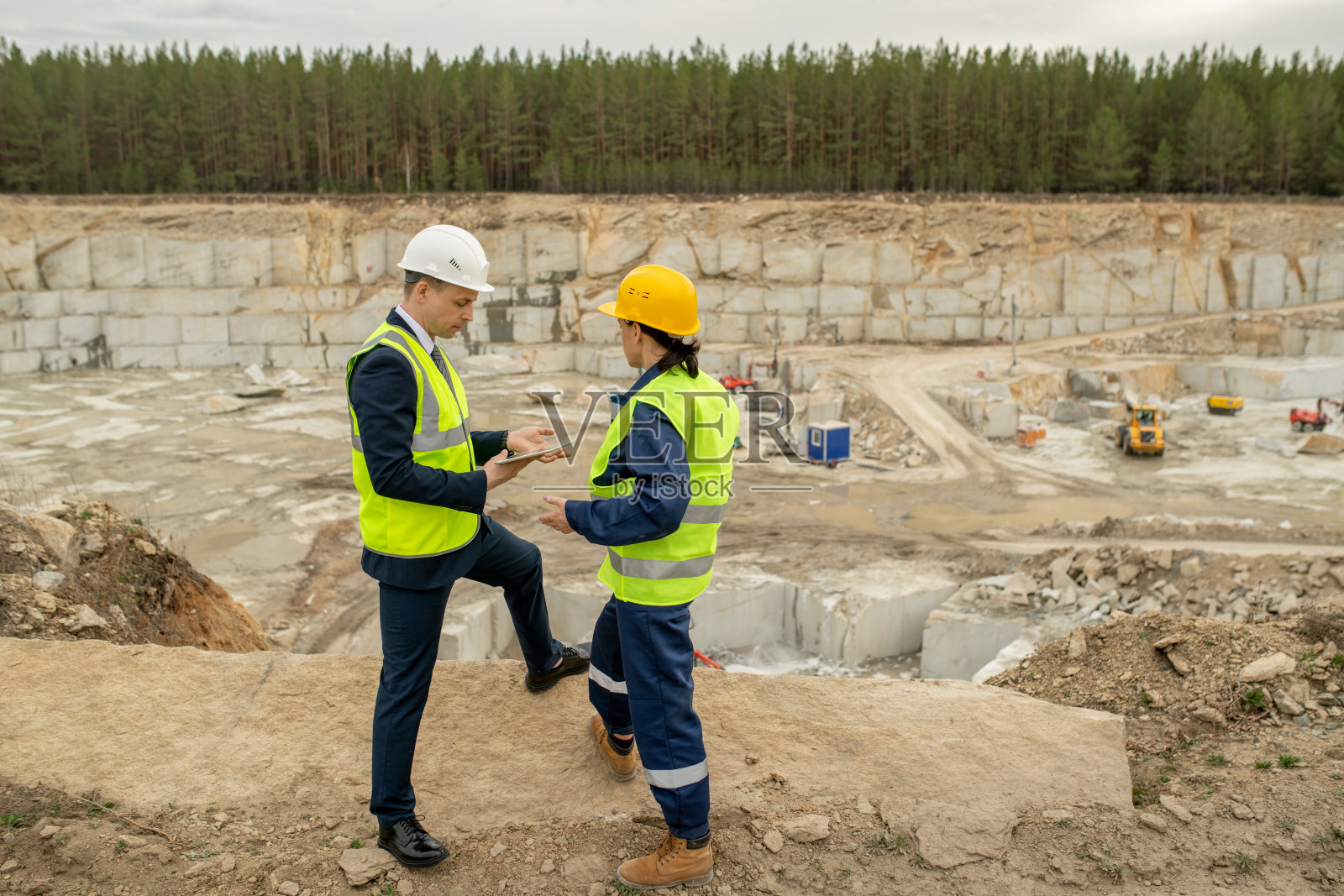 在采石场，年轻的工头和女工程师互动照片摄影图片