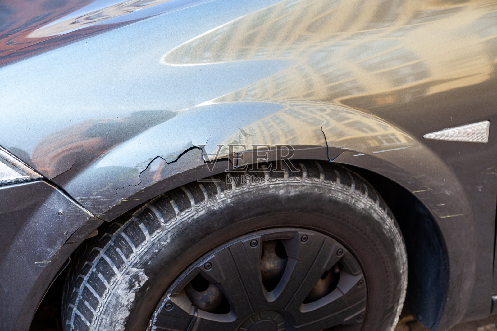 车祸后有裂缝、凹痕和划痕的汽车车轮和挡泥板侧面特写照片摄影图片