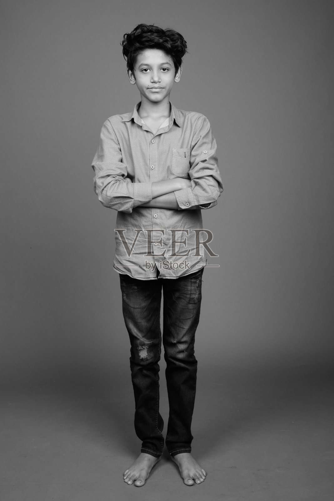 年轻的印度男孩穿着漂亮的休闲服装，背景为灰色照片摄影图片