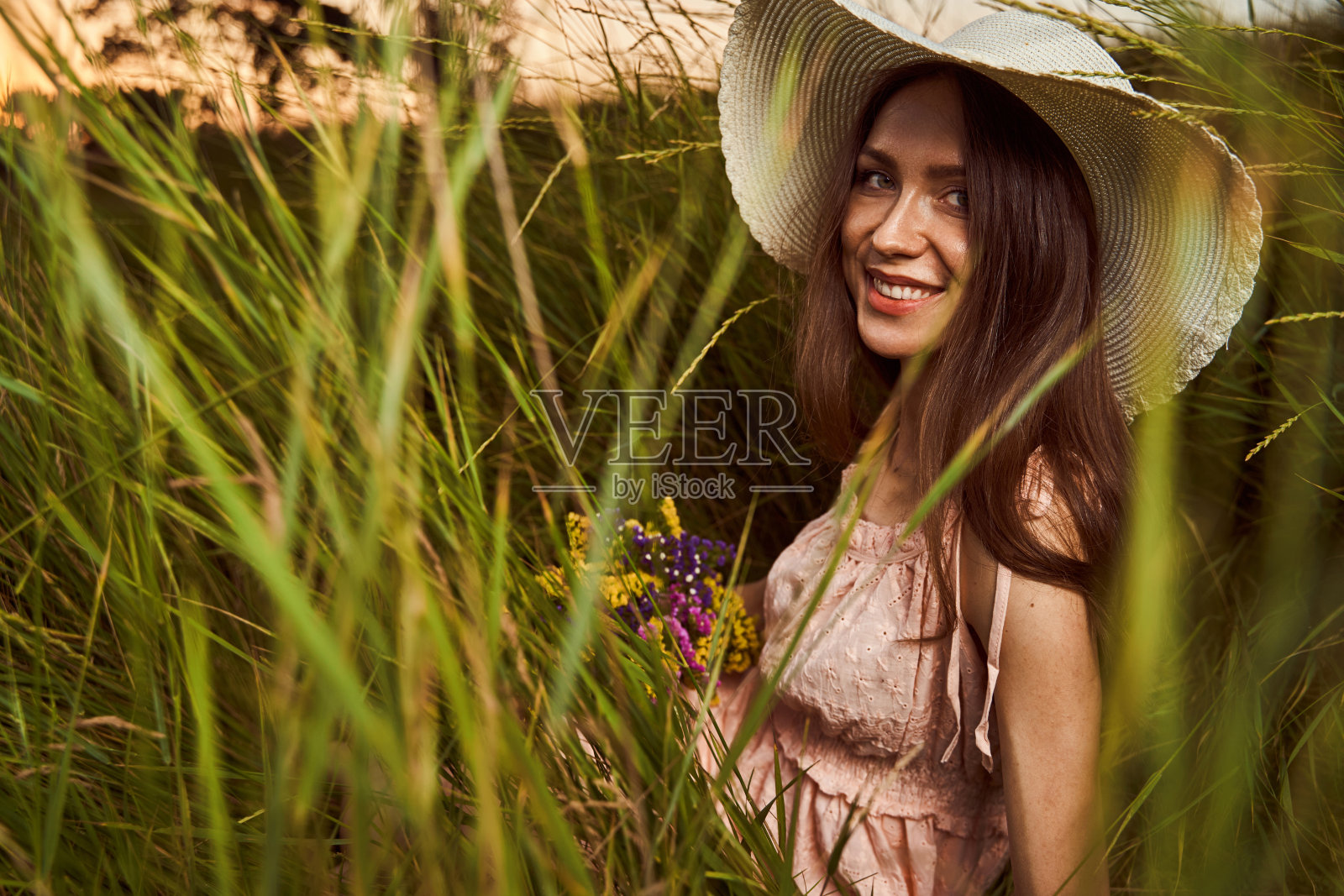 长发美女在草地上摆姿势照片摄影图片