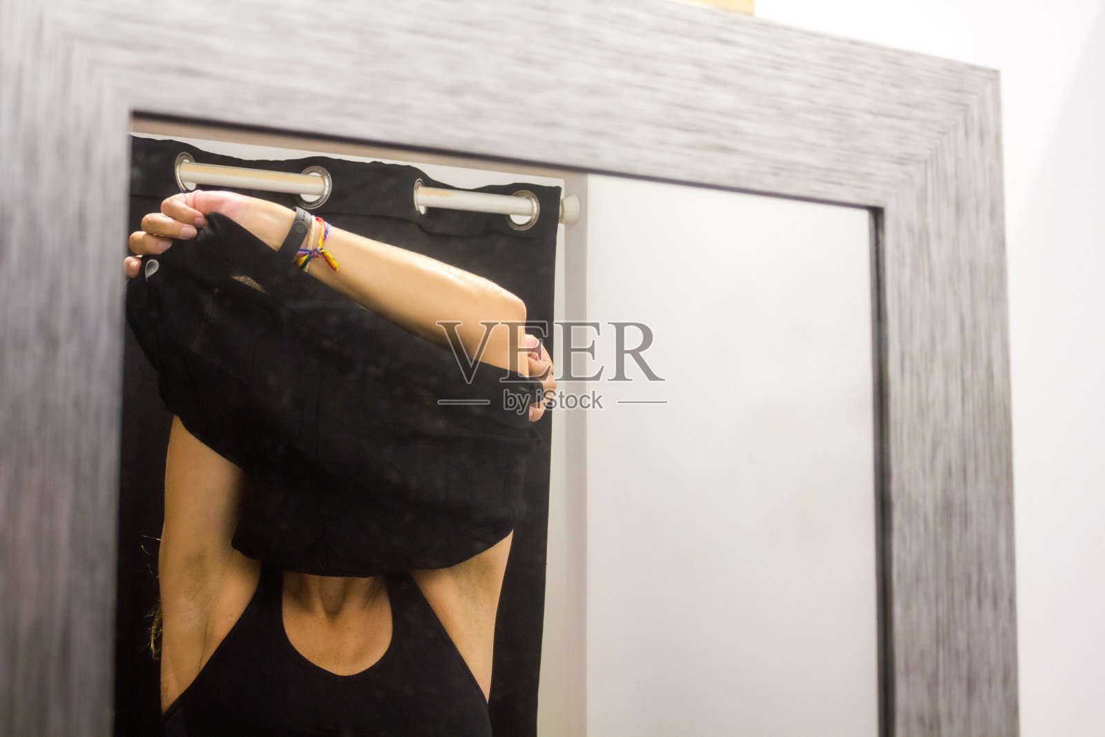 一位女士在一家服装店的试衣间里试穿衣服照片摄影图片