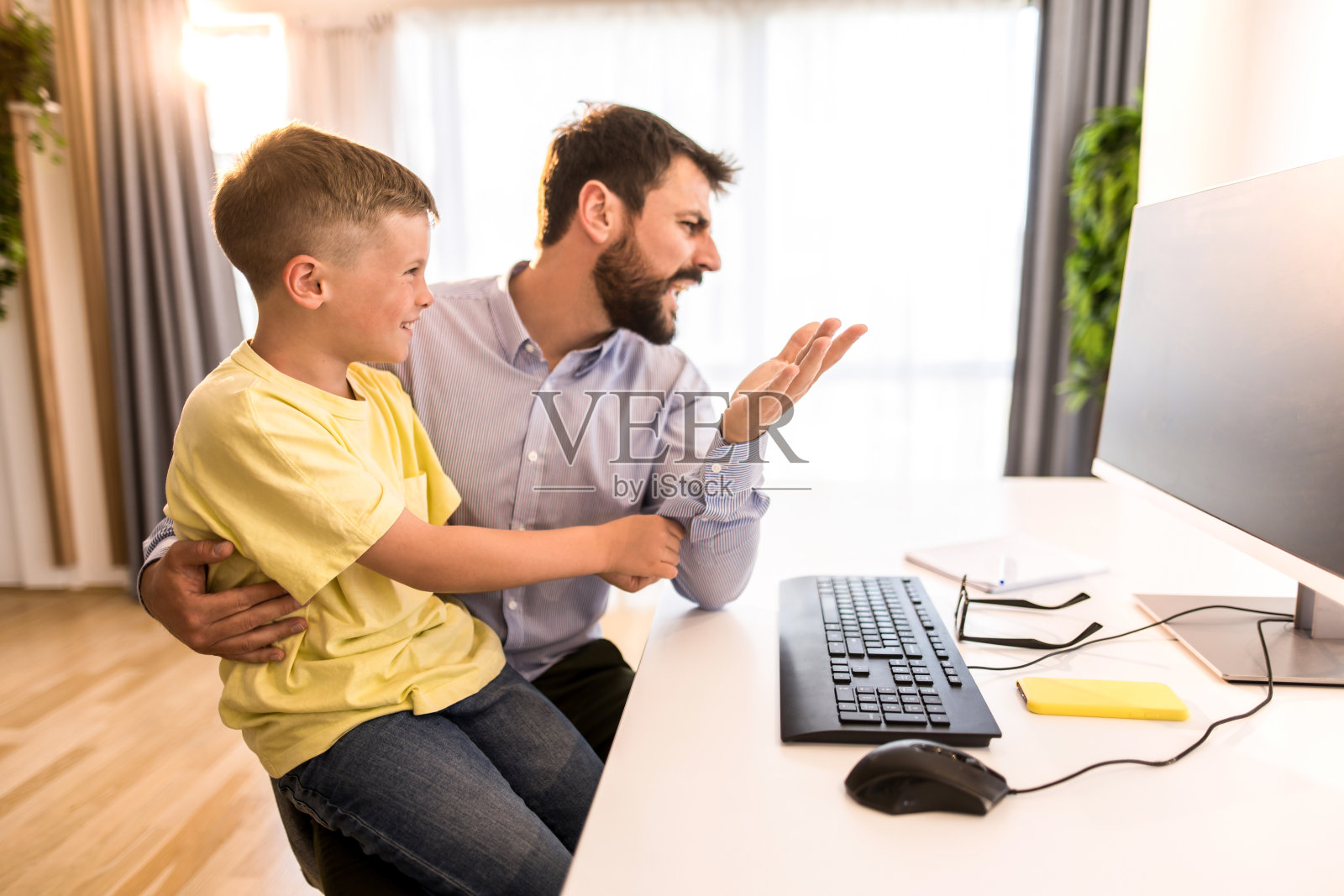 沮丧的父亲在小儿子的支持下工作。照片摄影图片