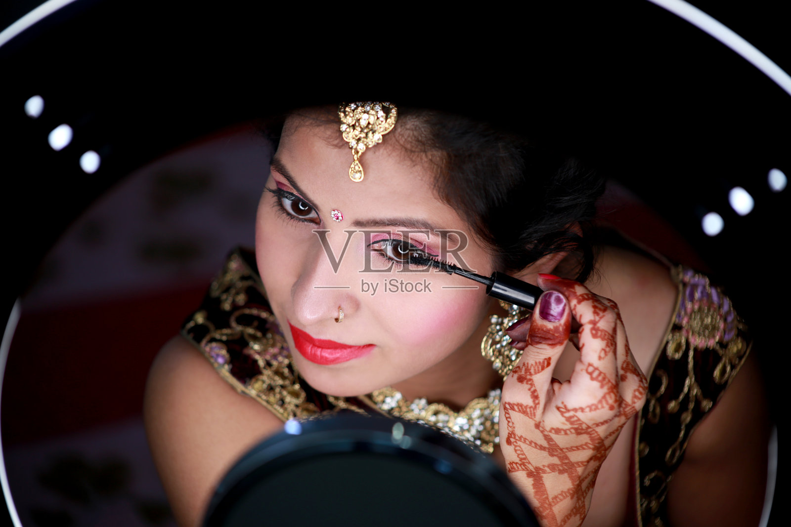 传统女性在睫毛上涂睫毛膏照片摄影图片