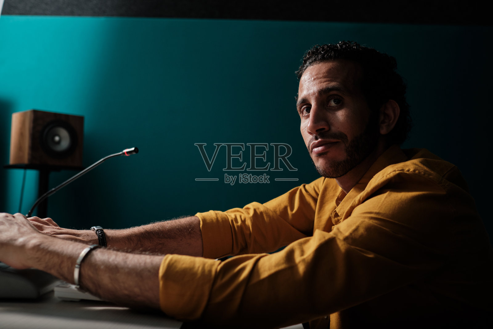 在录音室里拿着麦克风的男人照片摄影图片