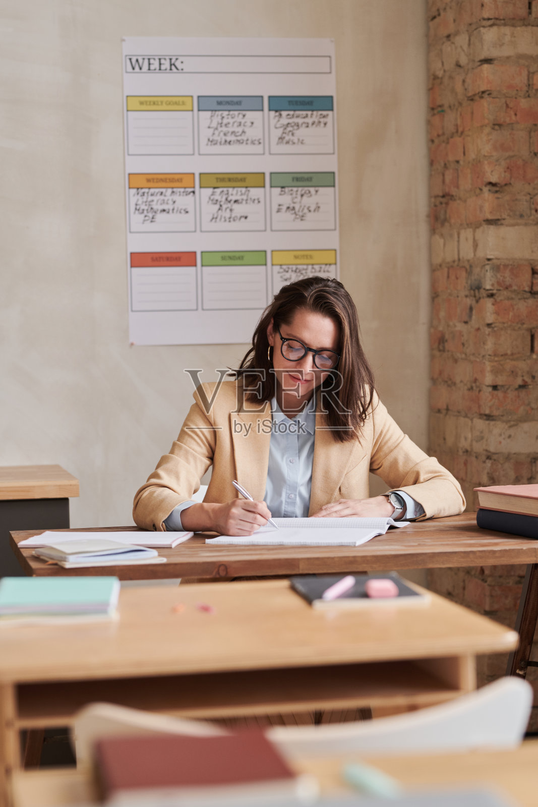 老师在课桌旁照片摄影图片