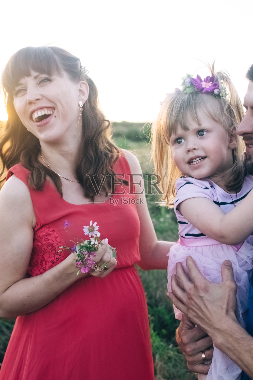 爸爸和女儿正看着怀孕的肚子。这家人即将迎来第二个孩子。小妹妹正在等她的弟弟。爱的亲戚亲吻和抚摸怀孕的肚子照片摄影图片