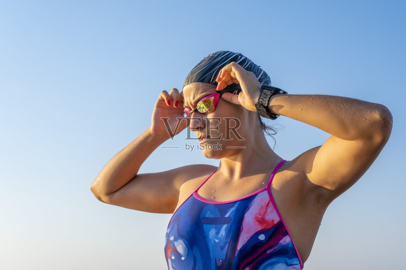 一个专注于运动的年轻女子正在修理她的泳镜照片摄影图片