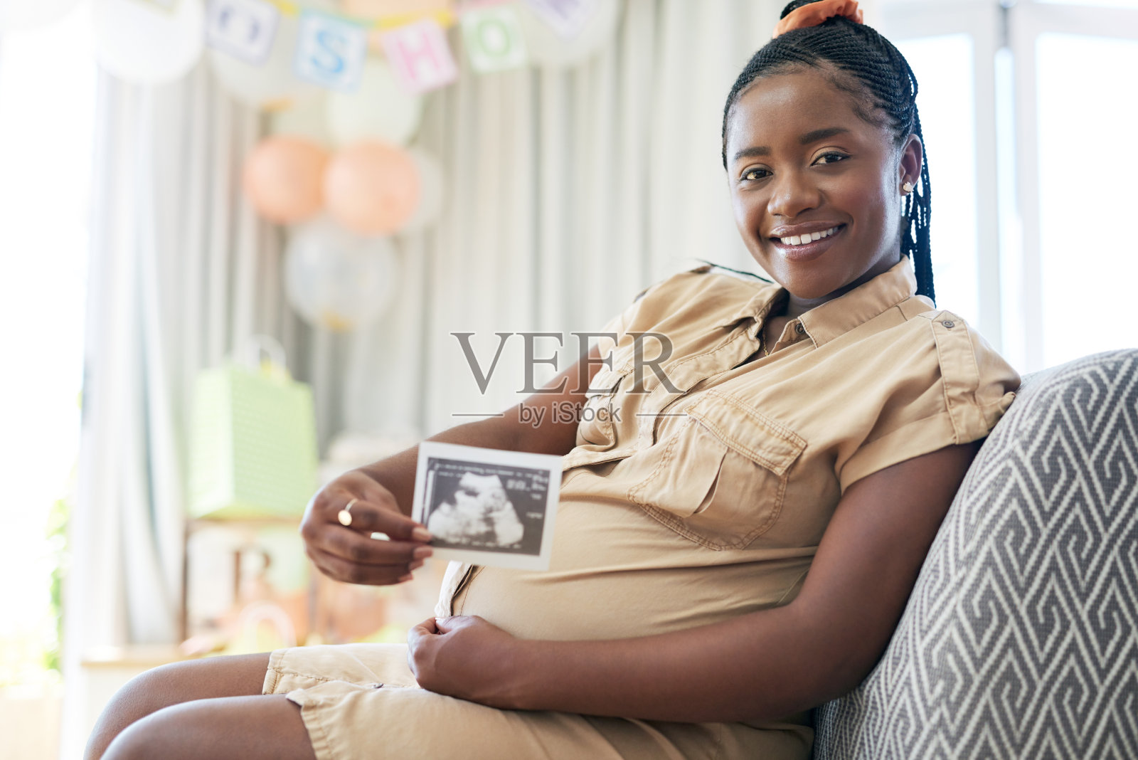 一位年轻的母亲抱着她未出生的孩子的超声波照片照片摄影图片