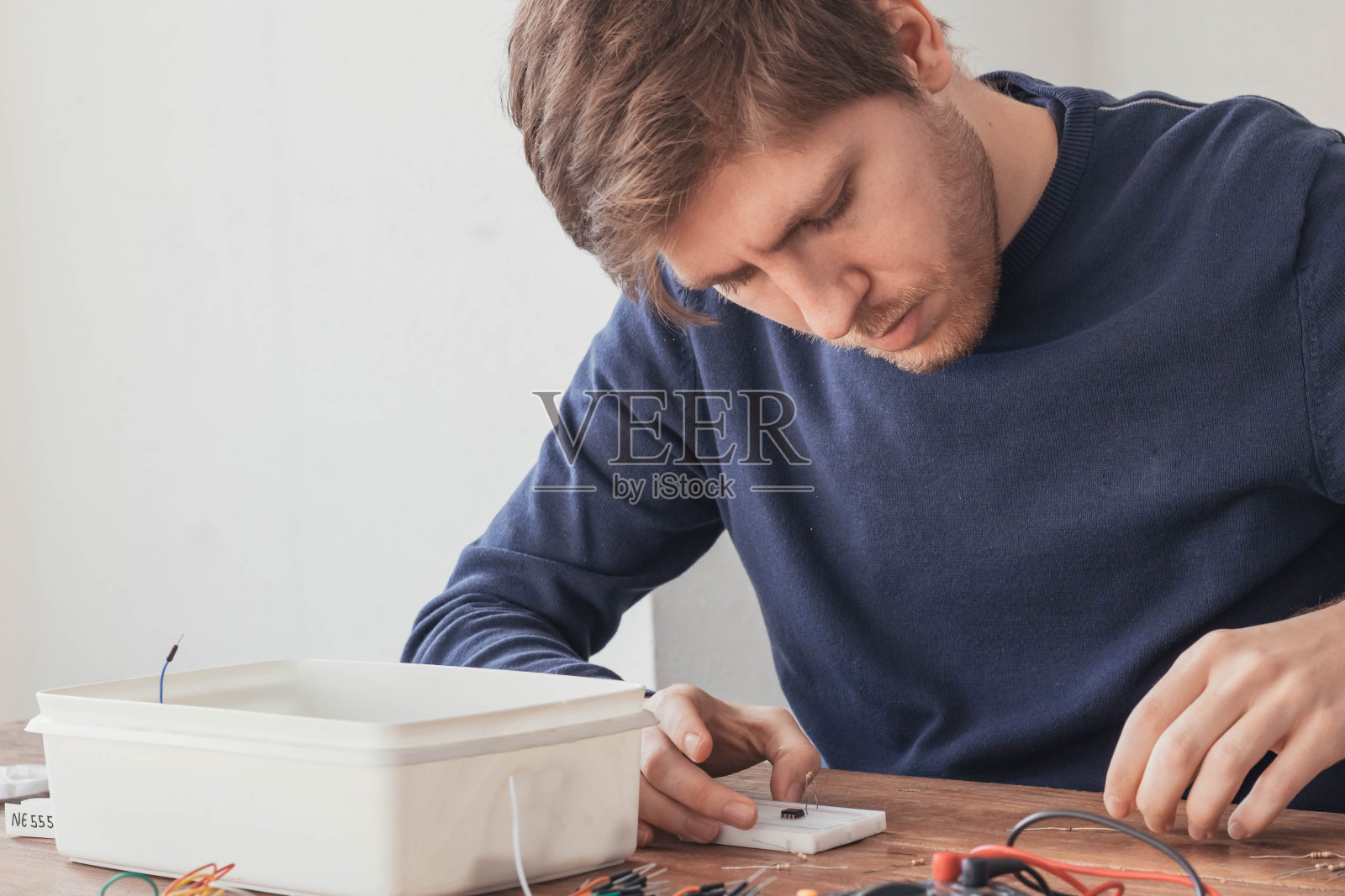 一个在家工作，做电路的年轻人照片摄影图片