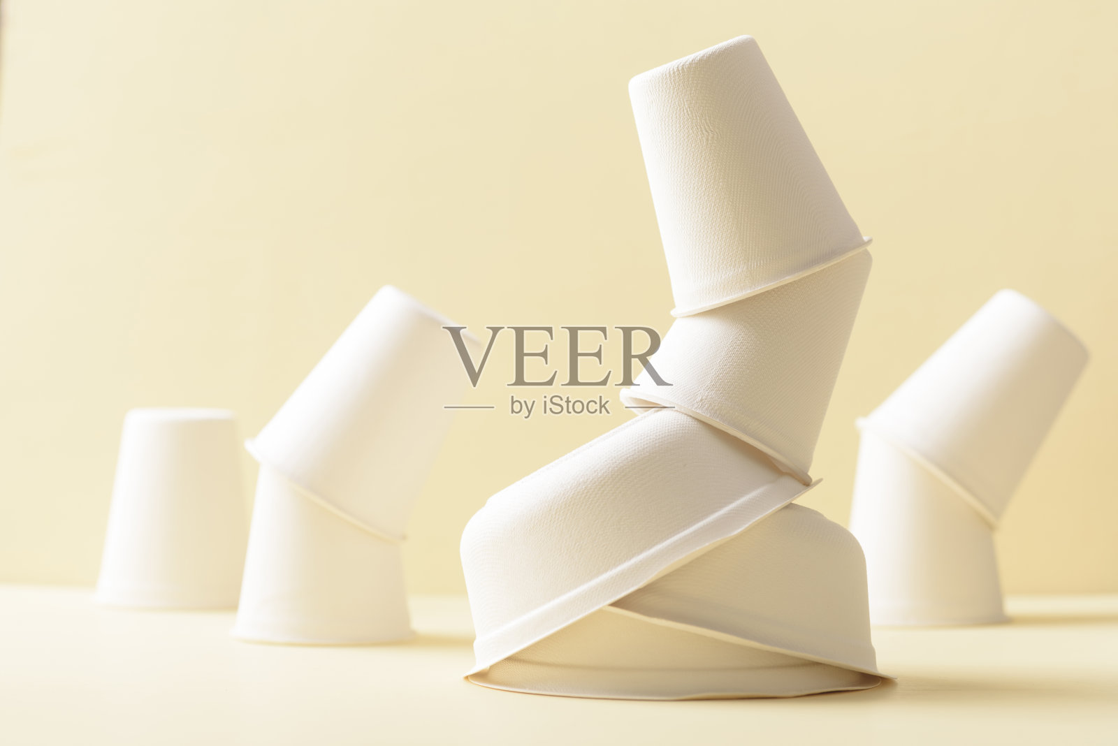 黄色背景上可生物降解的纸杯。照片摄影图片