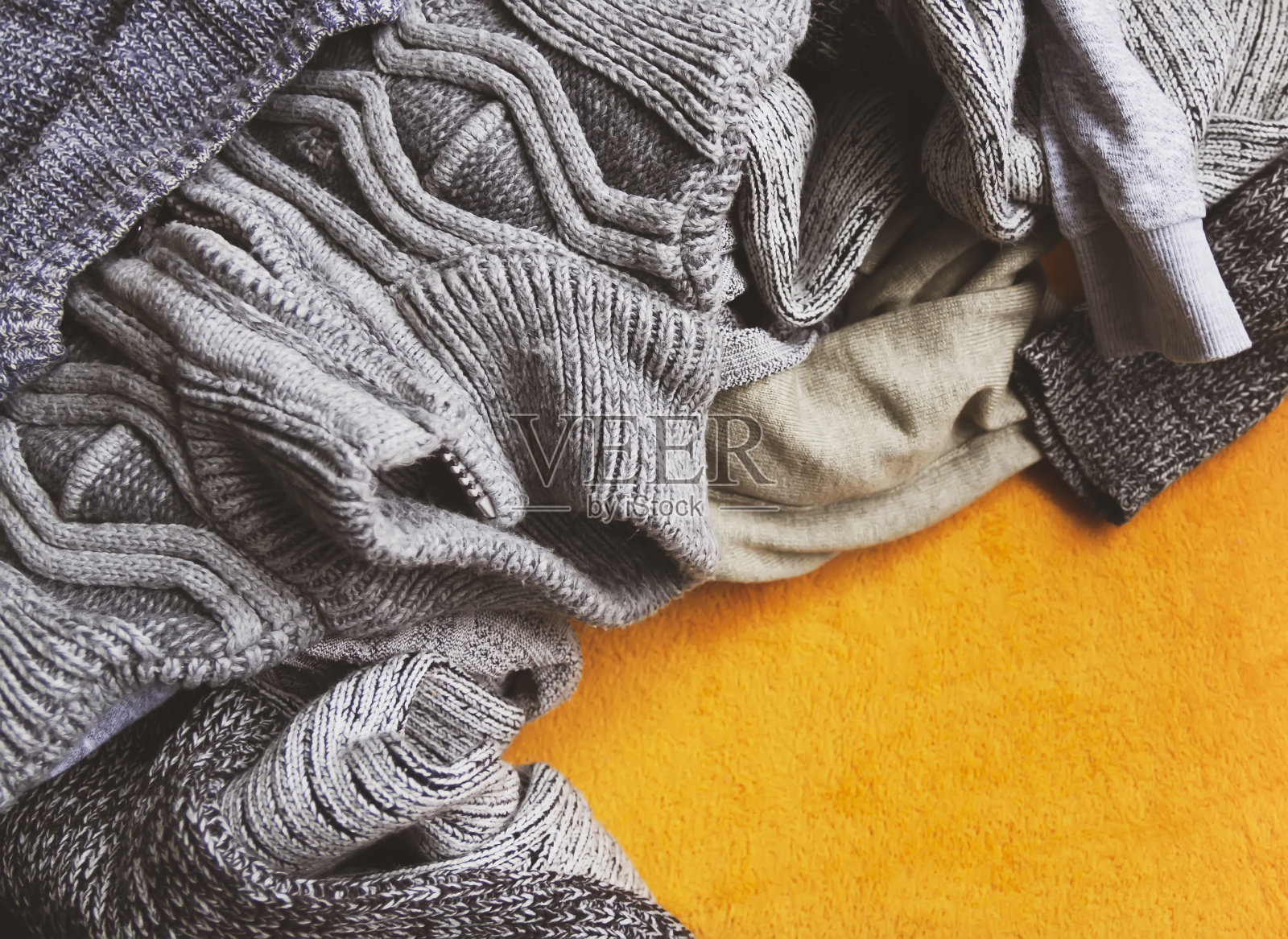 温暖的针织套衫和毛衣在明亮的黄色背景照片摄影图片