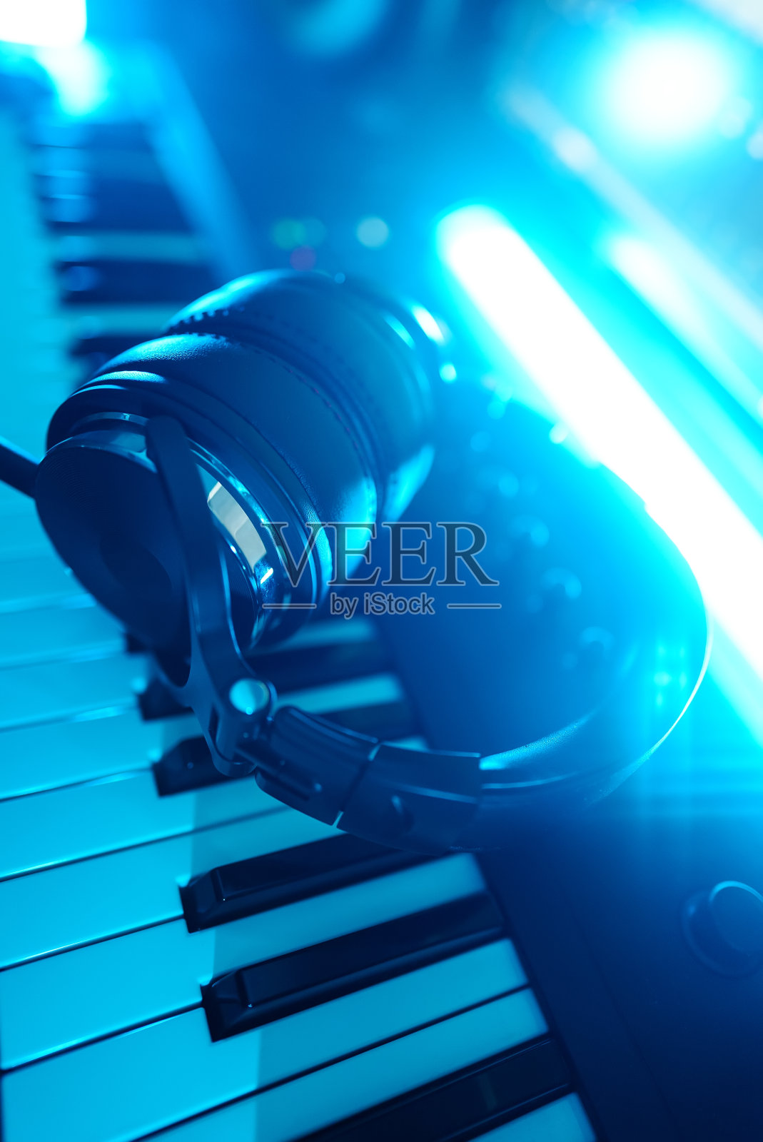 耳机放在钢琴键盘上。录音室的概念。照片摄影图片