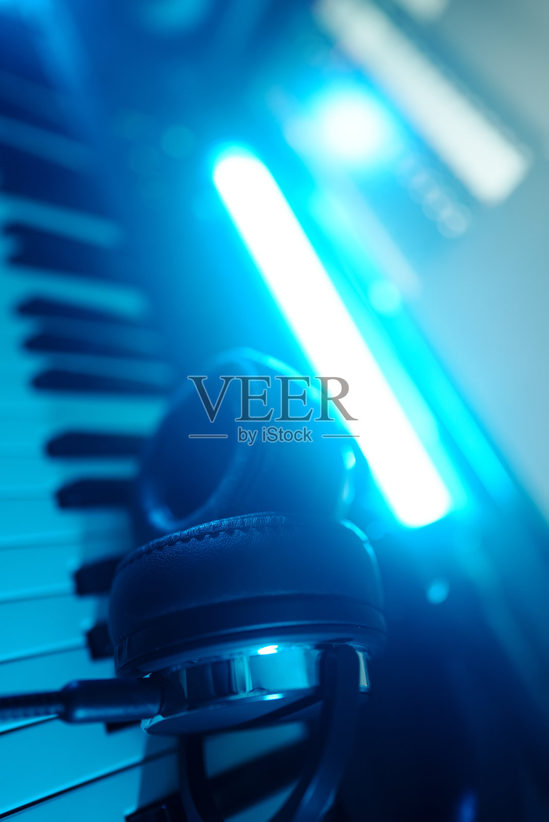 耳机放在钢琴键盘上。录音室的概念。照片摄影图片