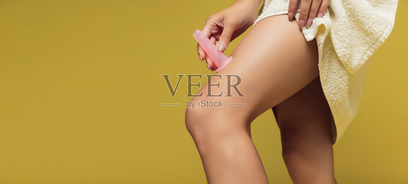 裁剪的工作室形象苗条，晒黑的女性腿孤立在黄色的背景。摩天观景轮照片摄影图片