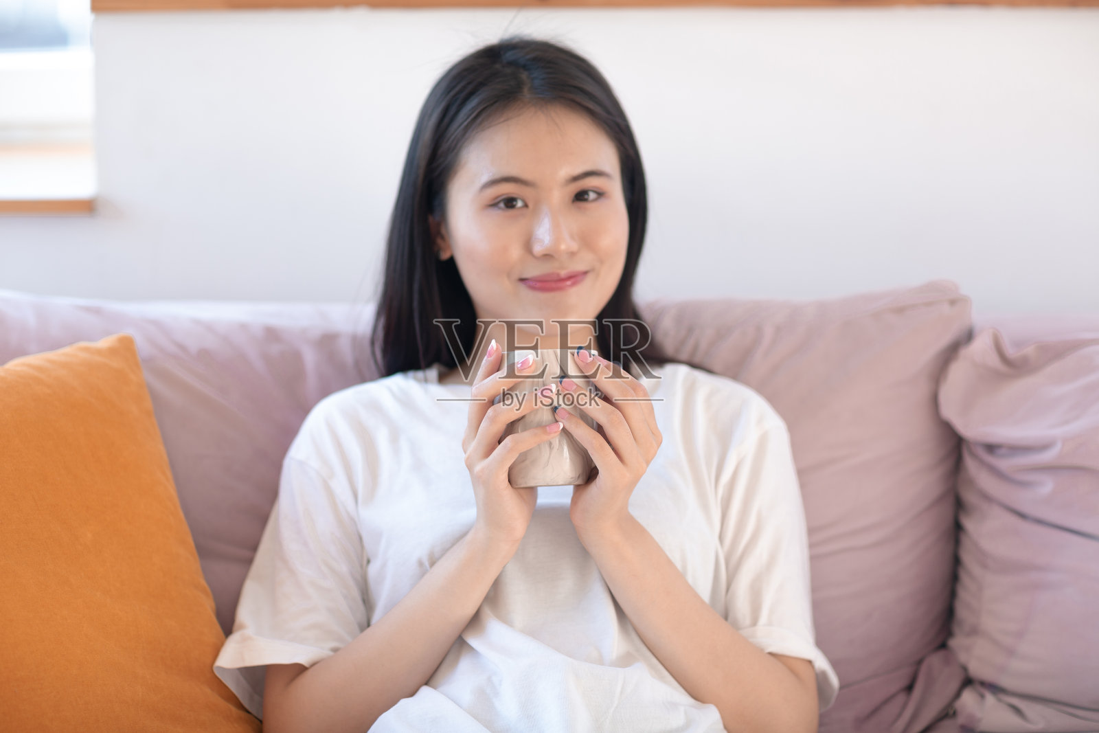 亚洲女人在公寓室内享受下午茶的肖像。照片摄影图片