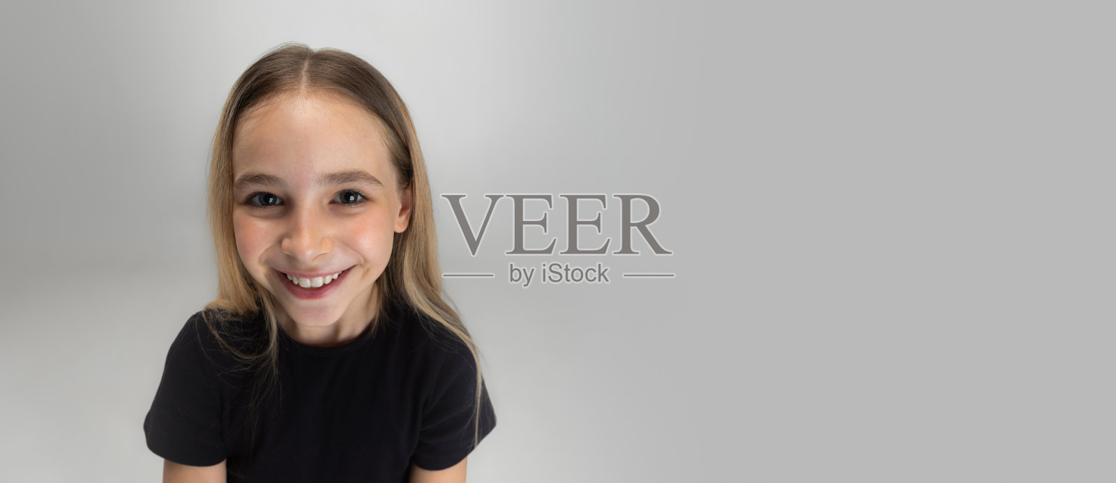 少年学校白种人女孩的肖像，穿着休闲装，在白色工作室背景下孤立地摆姿势。照片摄影图片