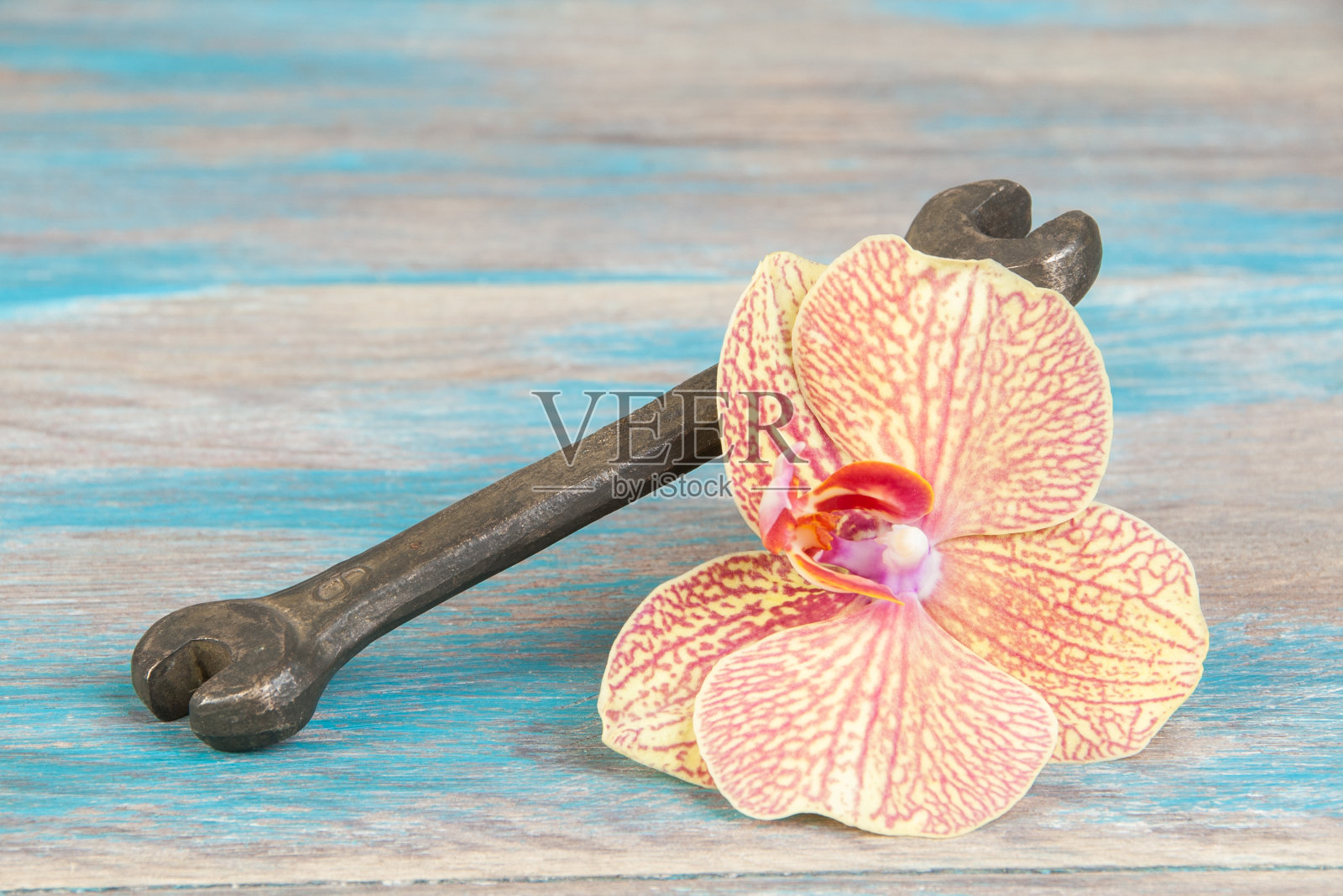 破旧背景上的古董青铜扳手照片摄影图片