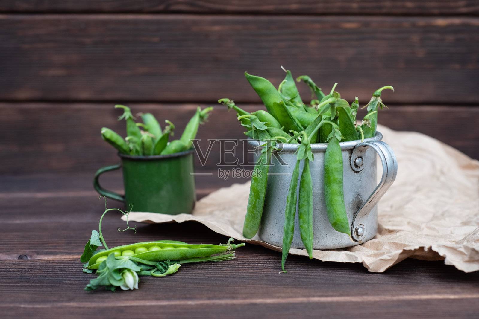 装在锡杯里的豆荚里的新鲜绿豌豆，成熟的有机蔬菜照片摄影图片