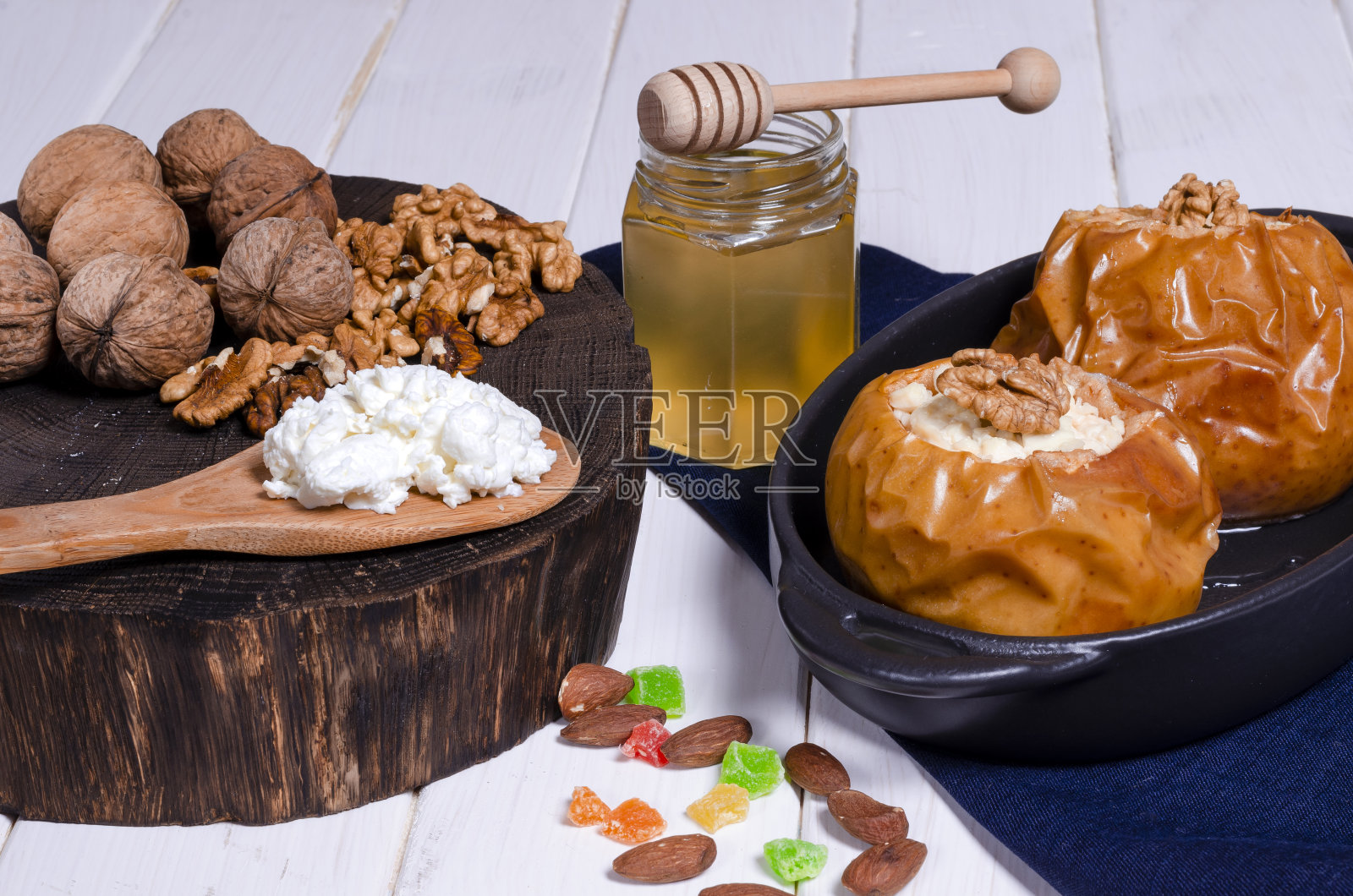 健康饮食的食物。苹果与白软干酪，蜂蜜和坚果烤在桌子上的烤架的形式照片摄影图片