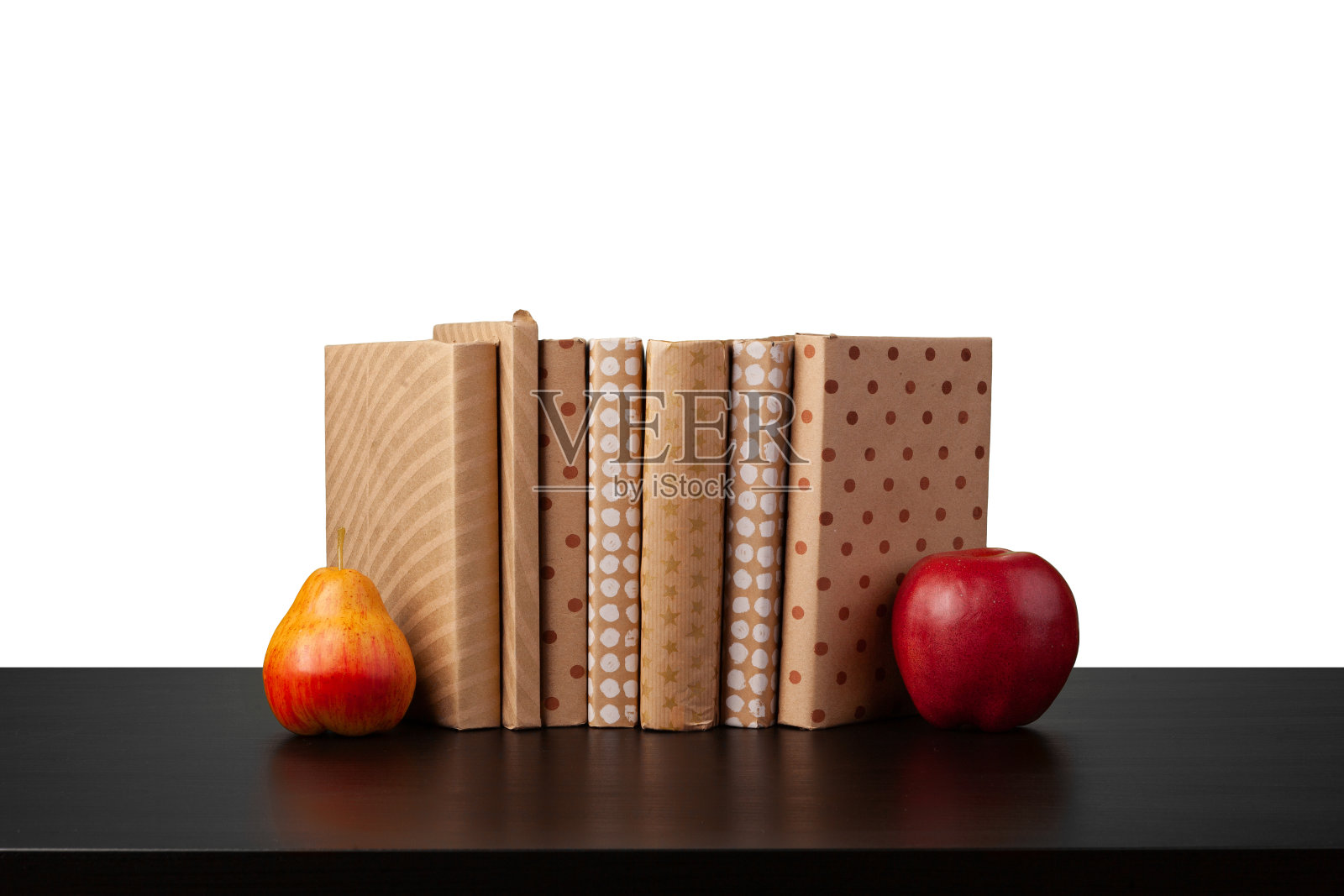 一堆书和苹果放在桌上，白色的背景照片摄影图片