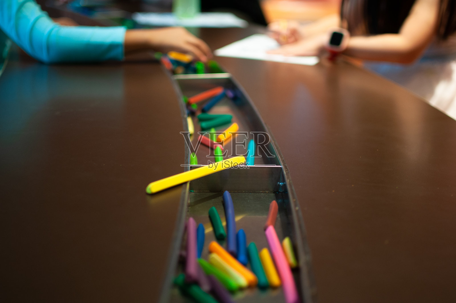 孩子们在纸上用蜡笔画画。照片摄影图片