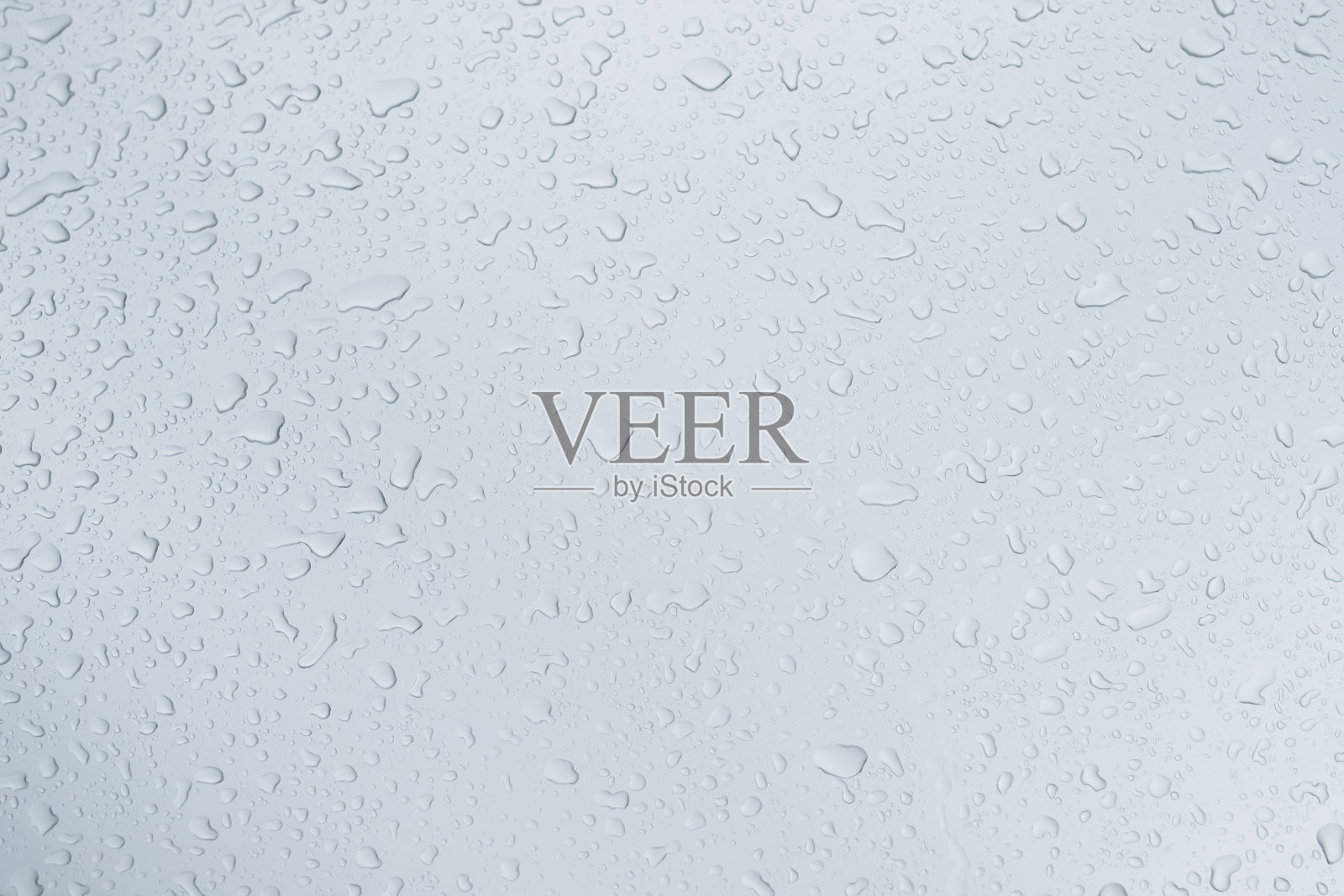 雨滴和露水。雨点落在灰色的车顶后停止下雨，选择性聚焦防水表面。软的焦点。留出书写文字背景的空间。照片摄影图片