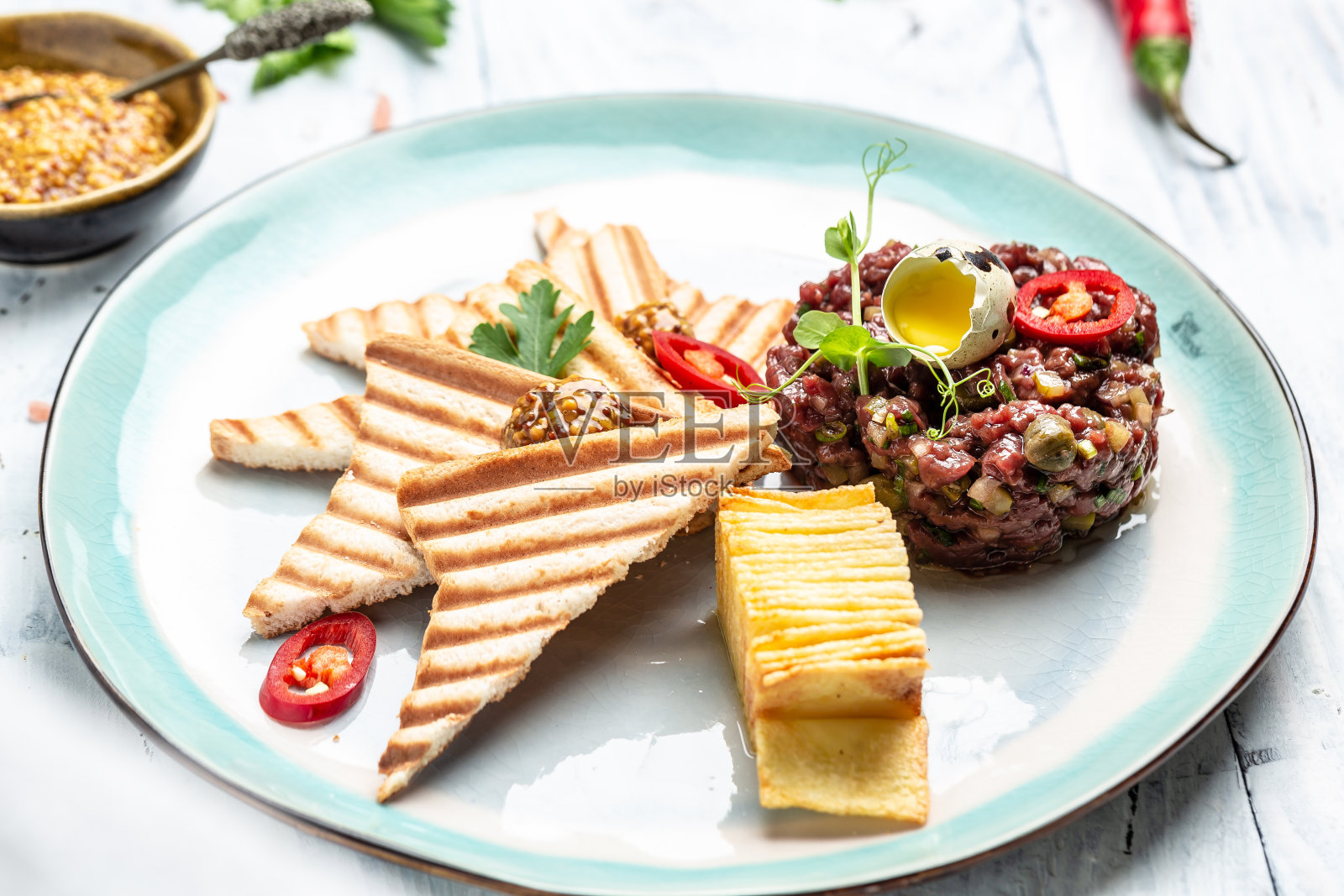 鞑靼牛排由生马肉馅和鹌鹑蛋黄制成。法国菜。美味的早餐或零食照片摄影图片