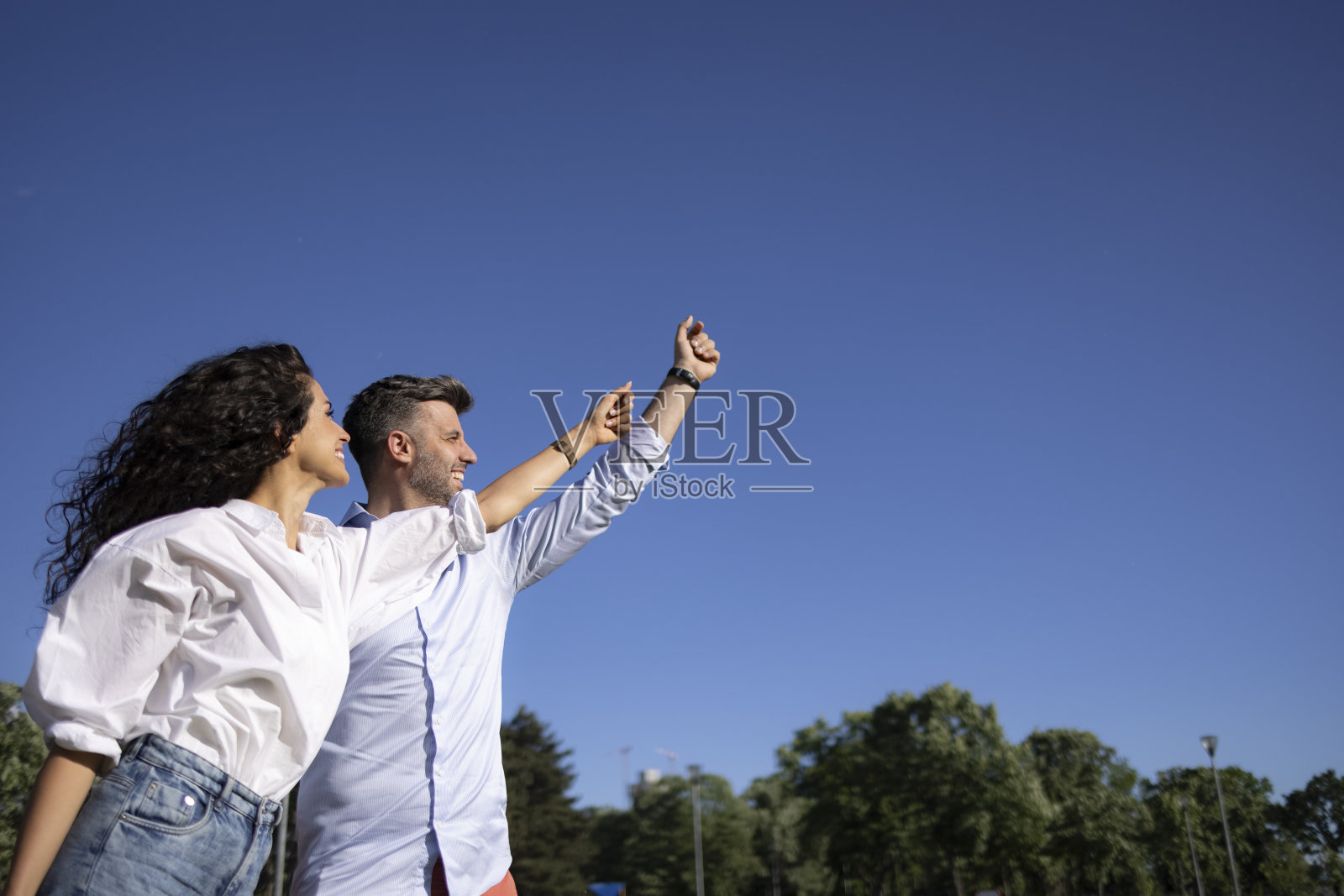 低角度，一对年轻的白人夫妇在野外放风筝照片摄影图片
