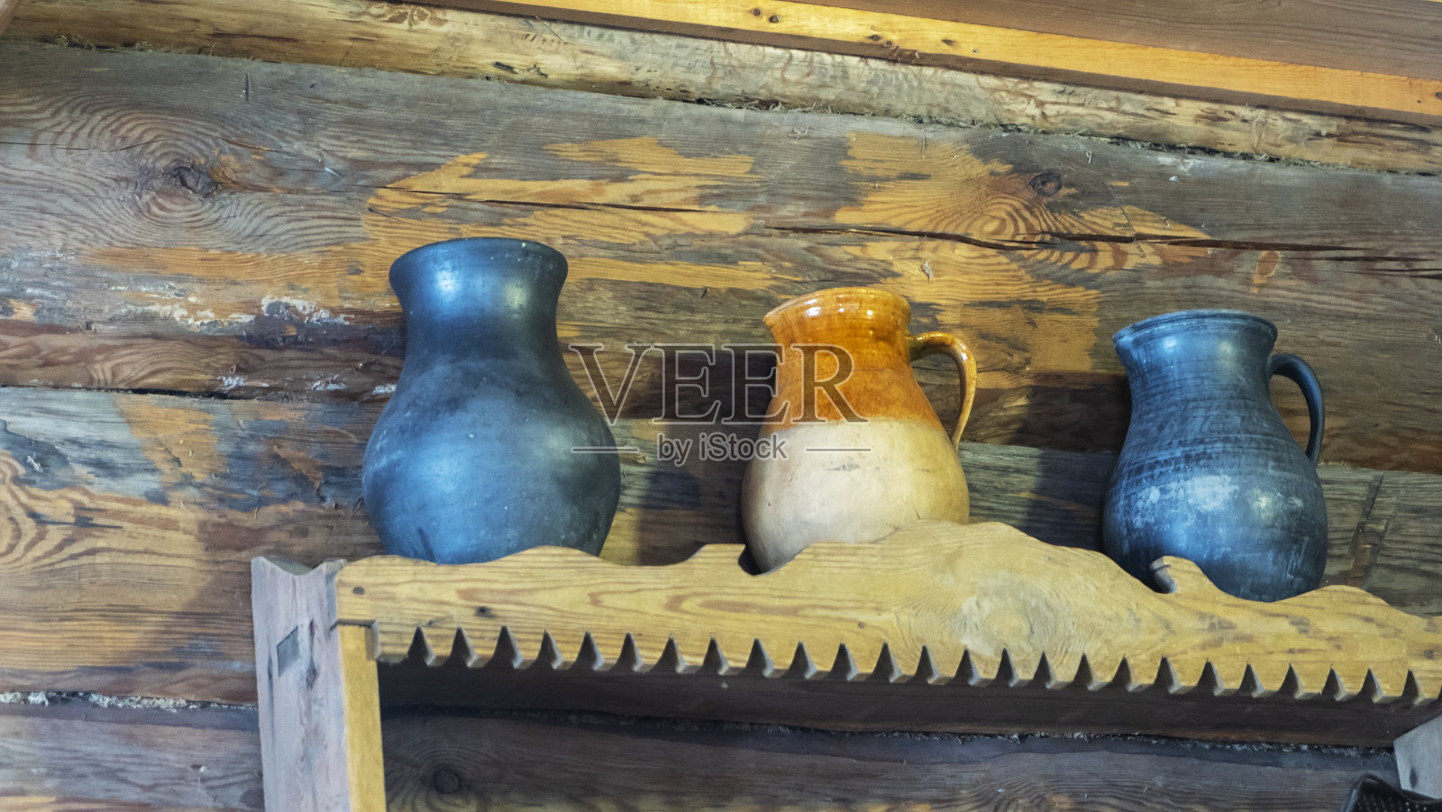 旧碗橱里有罐子和罐子。陶罐和壶放在架子上，背景是一堵木墙。乡村风格。照片摄影图片