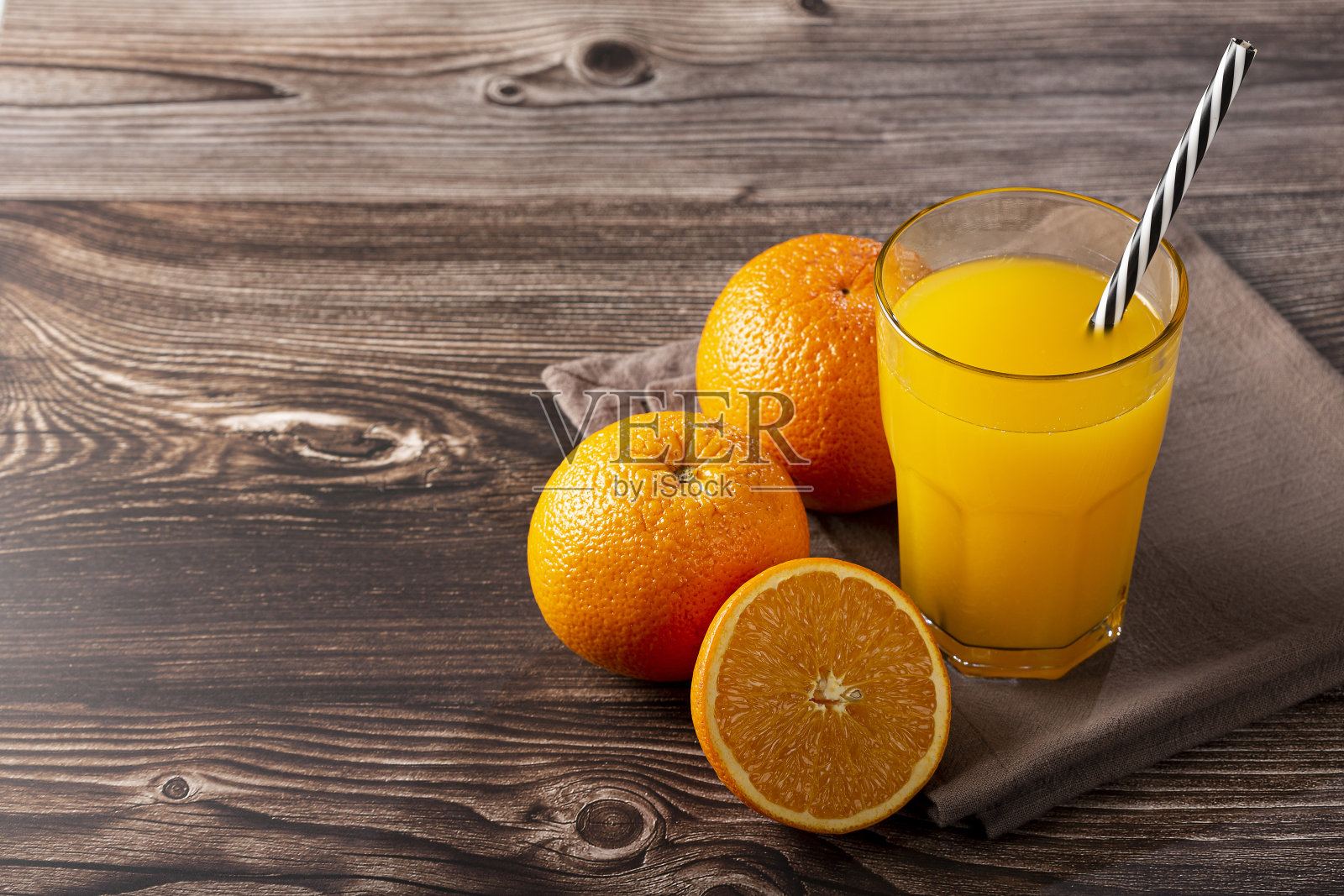 桌上有一杯橙汁。照片摄影图片