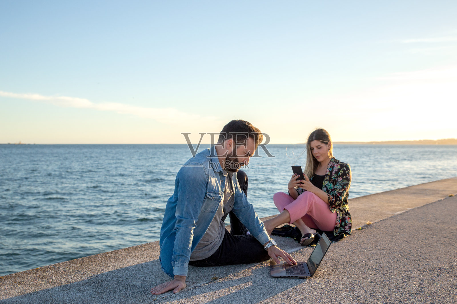 一对在河边远程工作的夫妇照片摄影图片