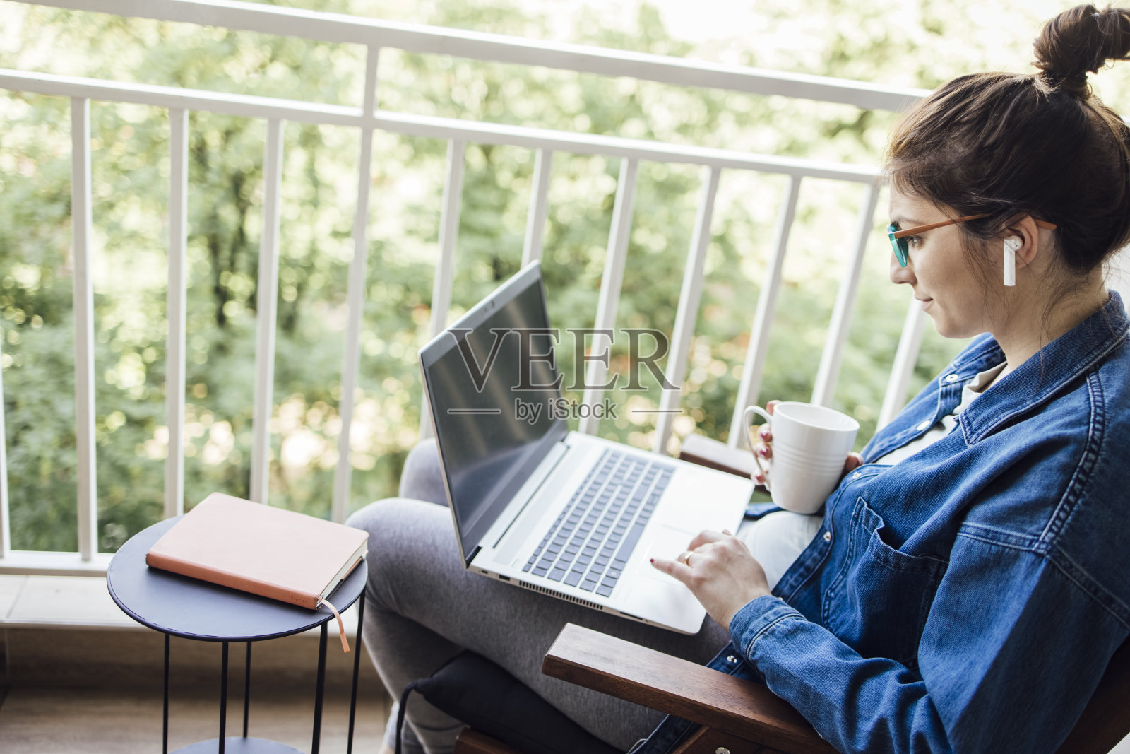 年轻的企业家在阳台上享受她的在线工作照片摄影图片